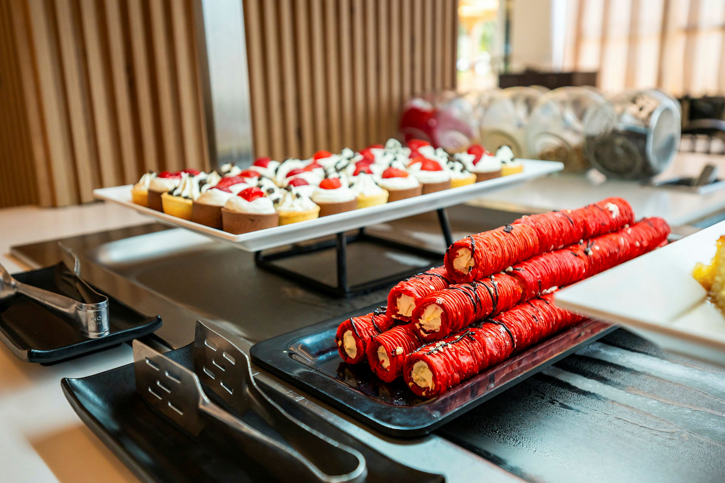 Et dessertbord med en tallerken små bakverk og ruller fylt med krem. (AI-generert tekst)