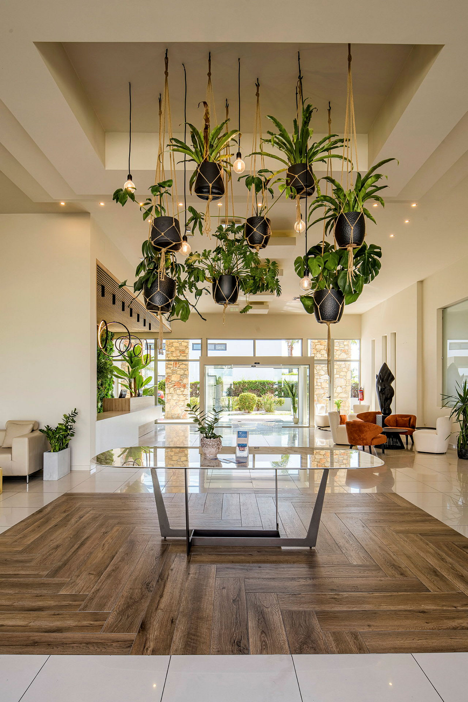 En moderne hotellobby med hengende planter og glassbord. (AI-generert tekst)