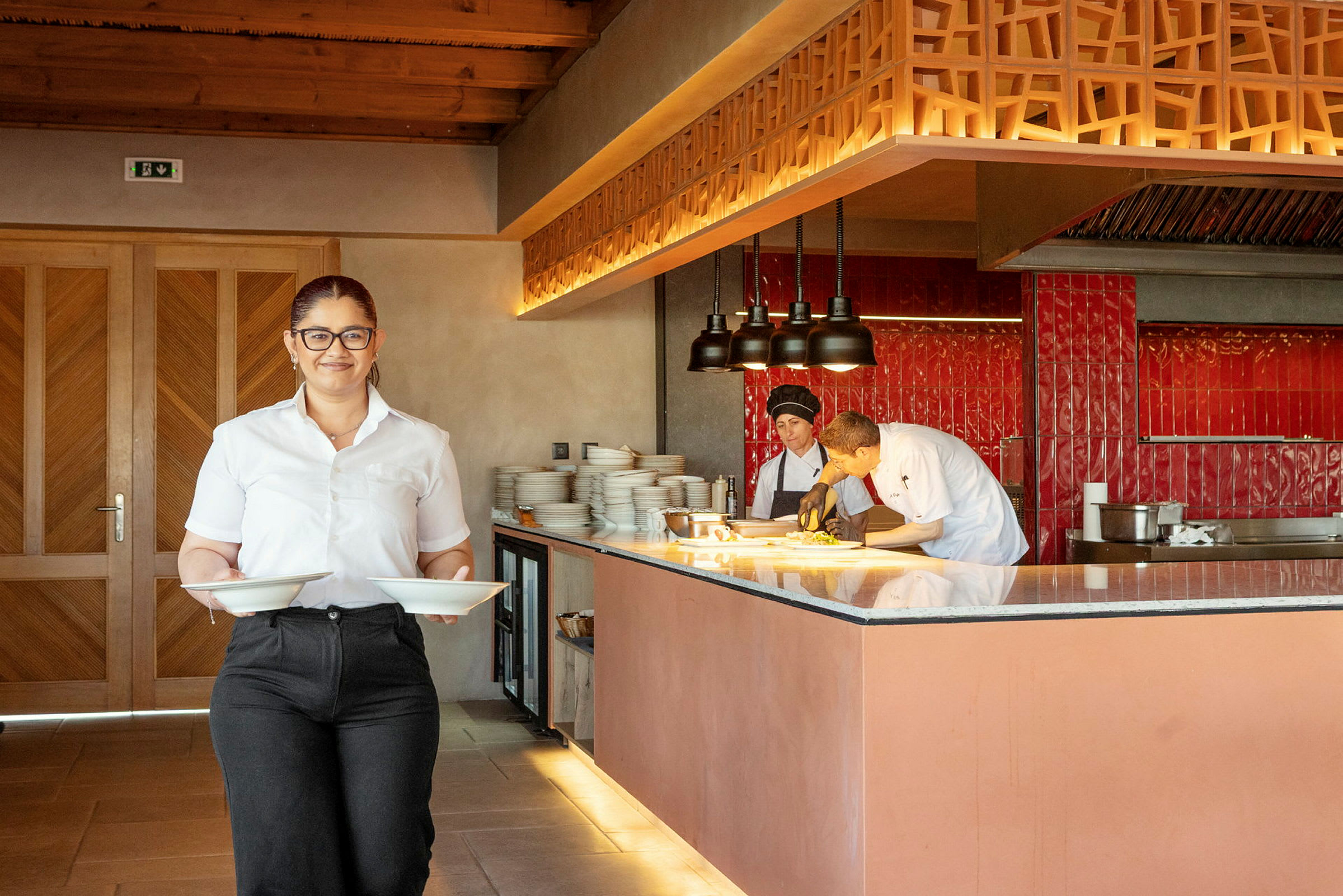 En restaurantinnredning med personale og kjøkken. (AI-generert tekst)