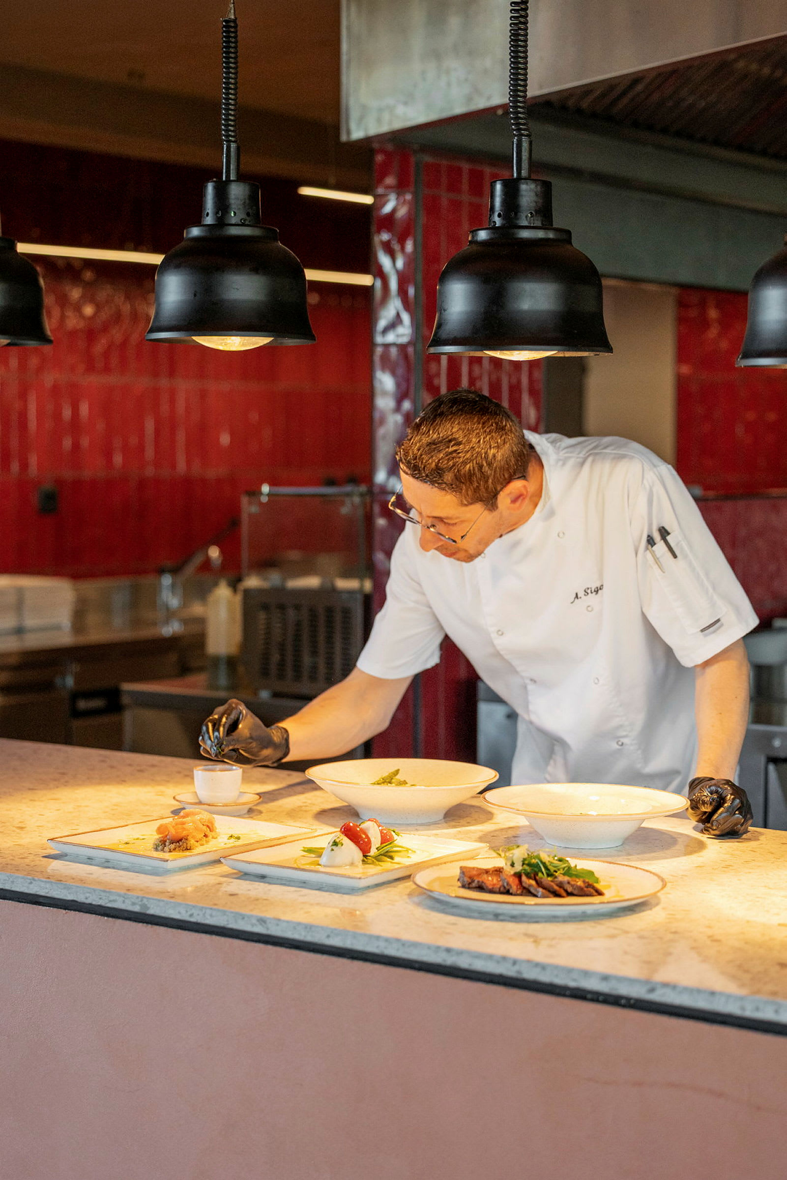Kokk som forbereder retter på en benkeplate på et kjøkken. (AI-generert tekst)