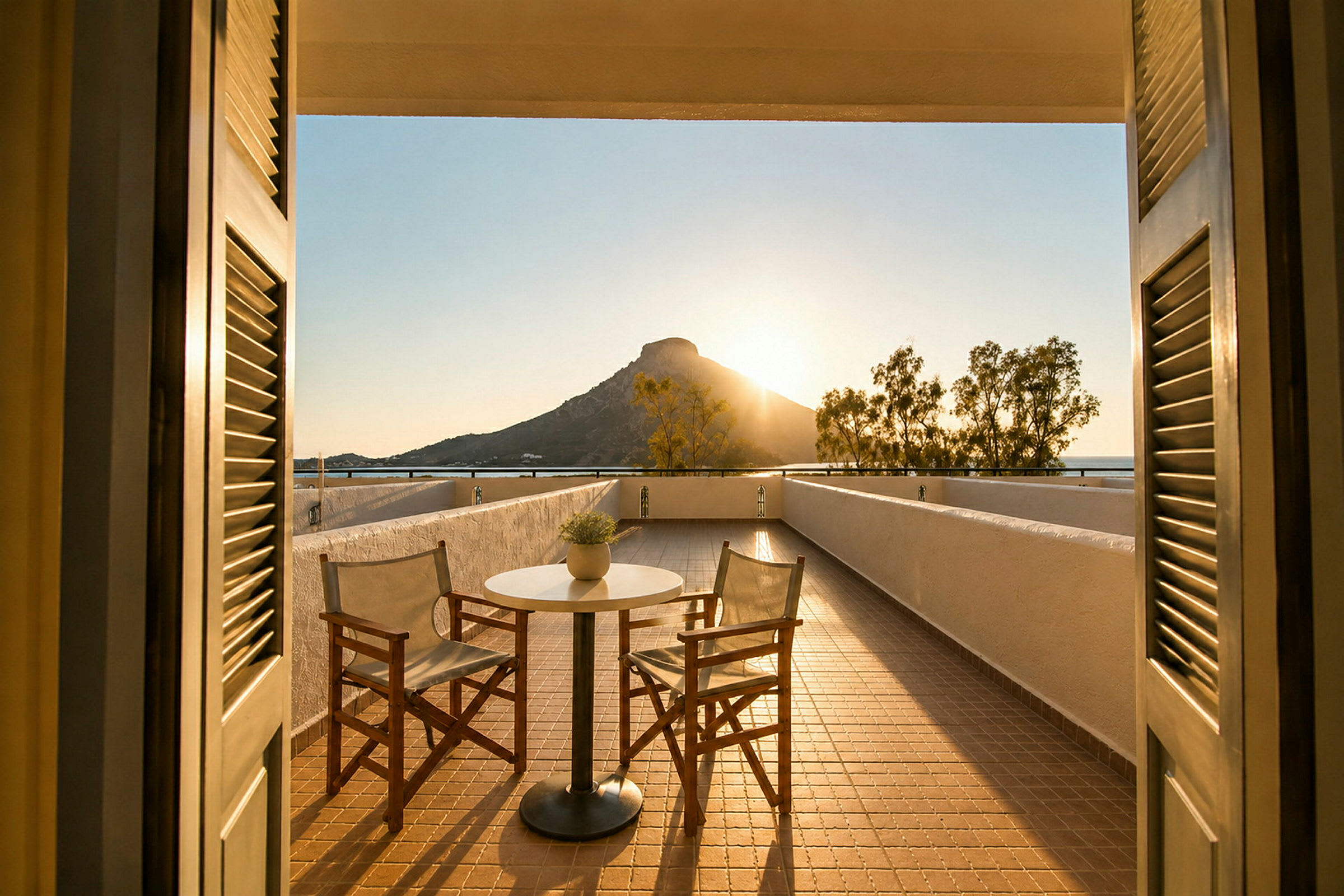 En terrasse med to stoler og et bord, med utsikt over et fjell ved solnedgang. (AI-generert tekst)