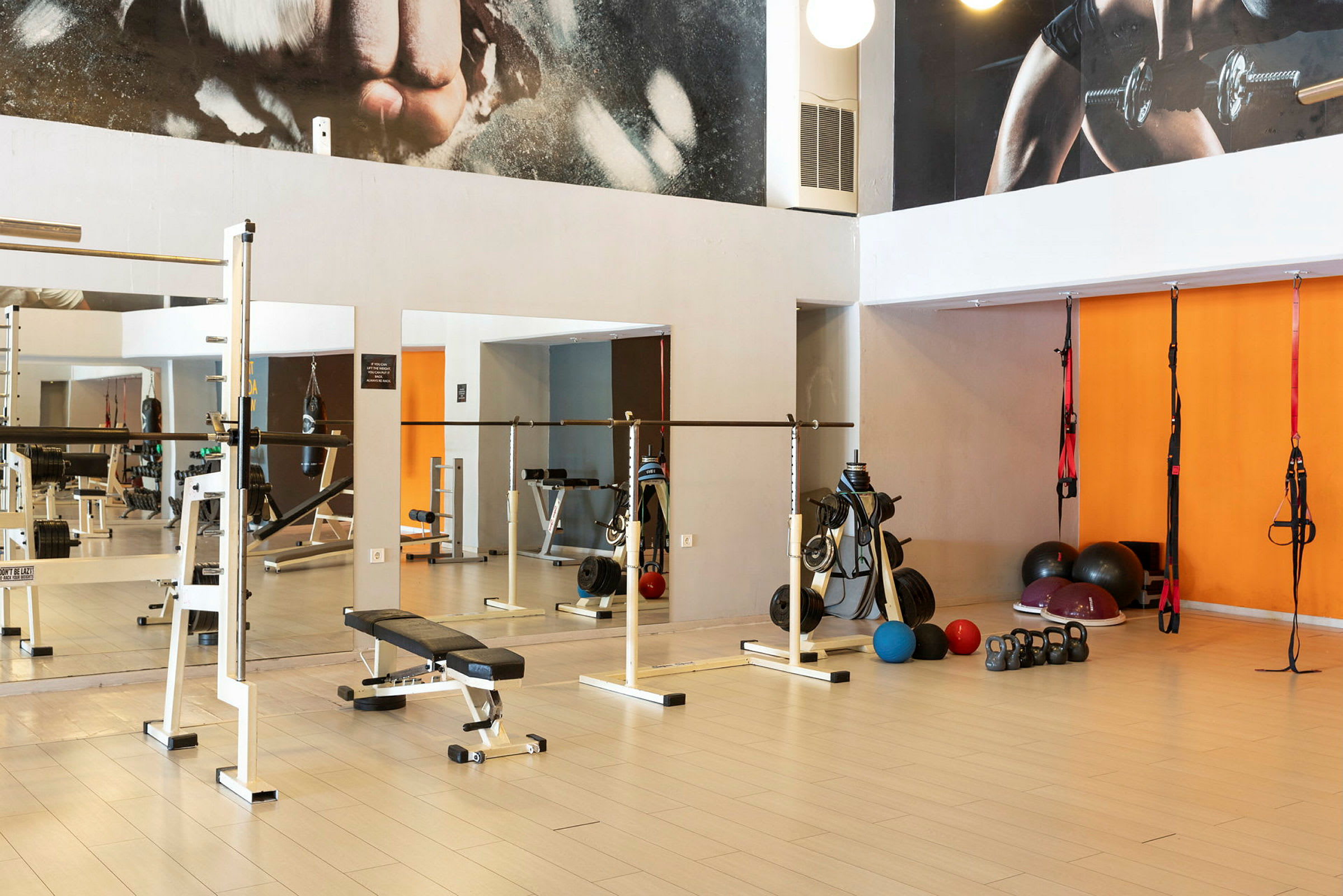 Et treningsstudio med utstyr som manualer, benker og kettlebells. (AI-generert tekst)