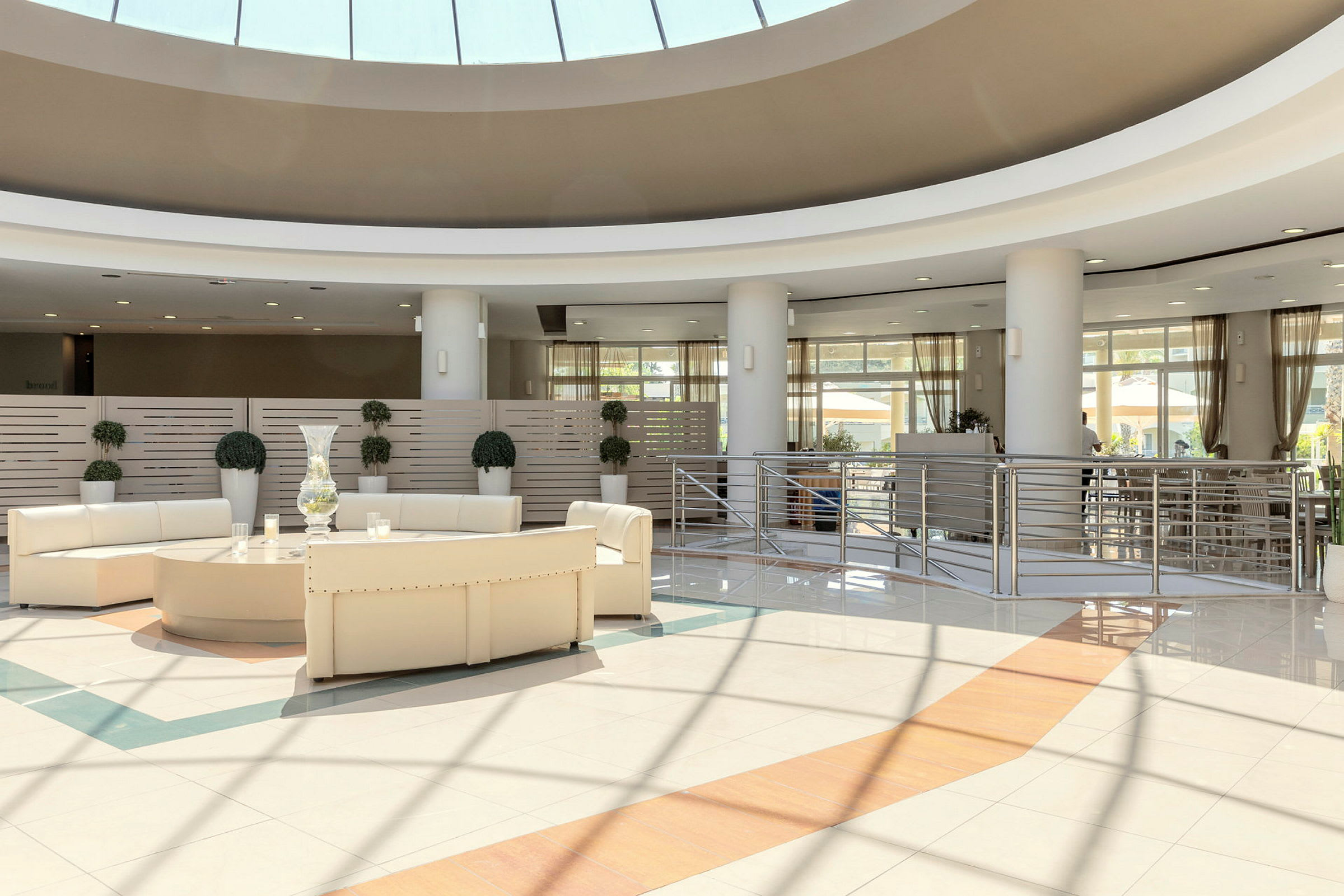 Bilde av en moderne hotellobby med hvite møbler og store vinduer. (AI-generert tekst)