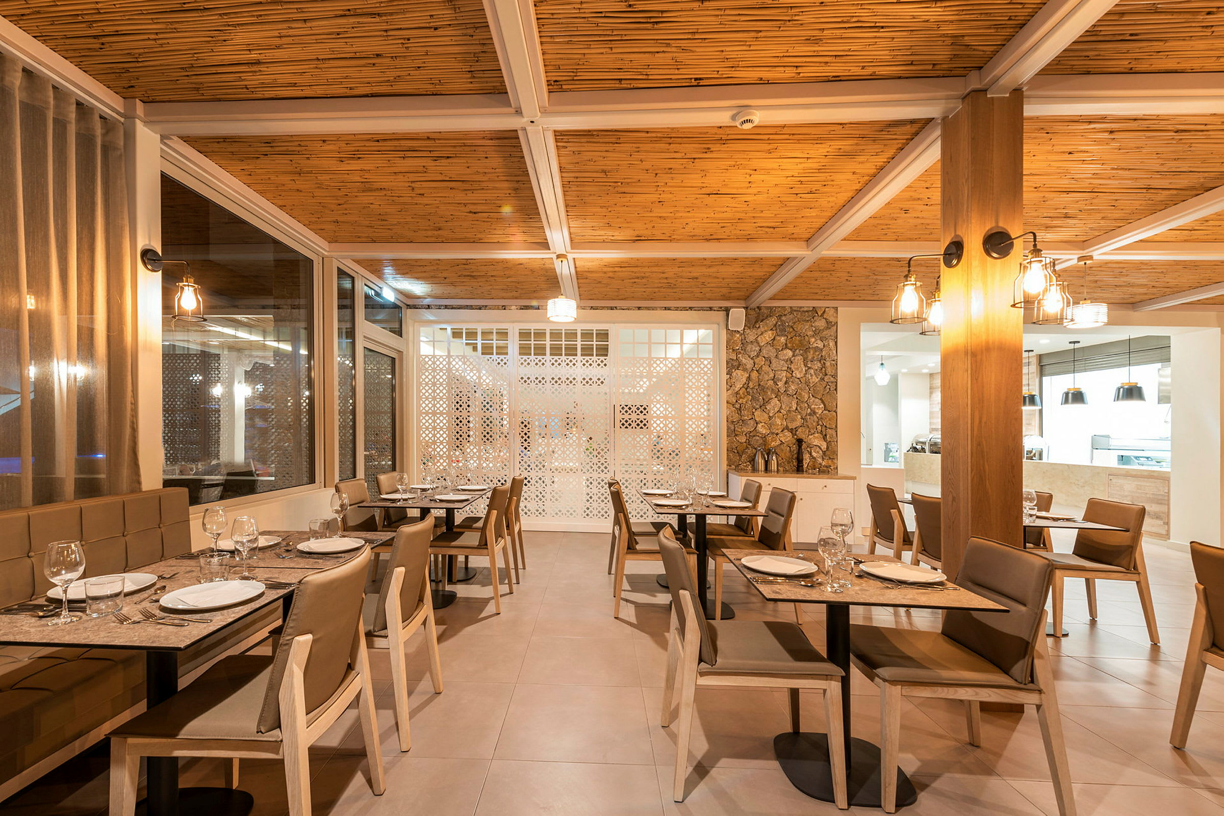 Interiør av en restaurant med dekkede bord og stoler. (AI-generert tekst)