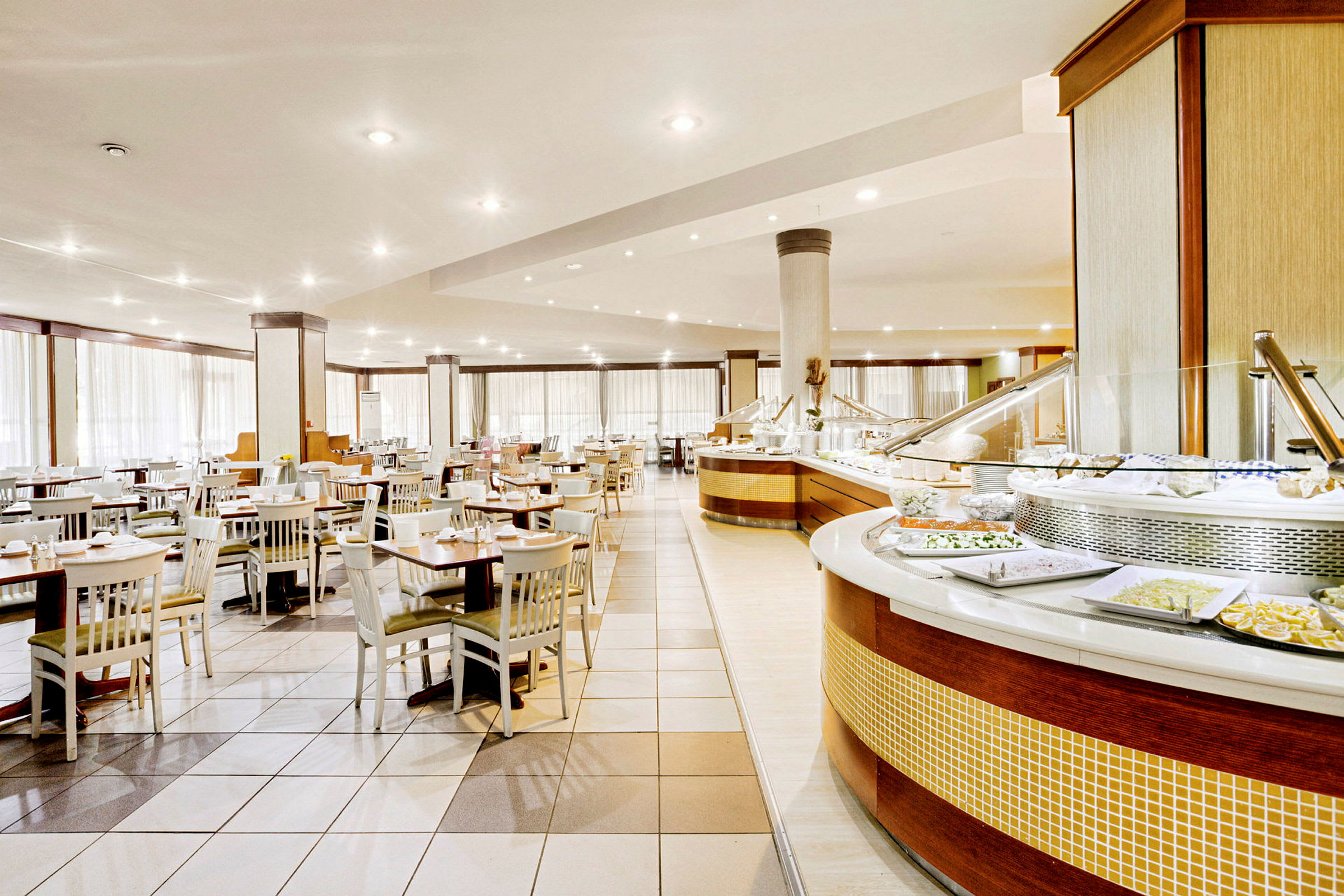 Stor spisesal med mange bord og en buffet. (AI-generert tekst)