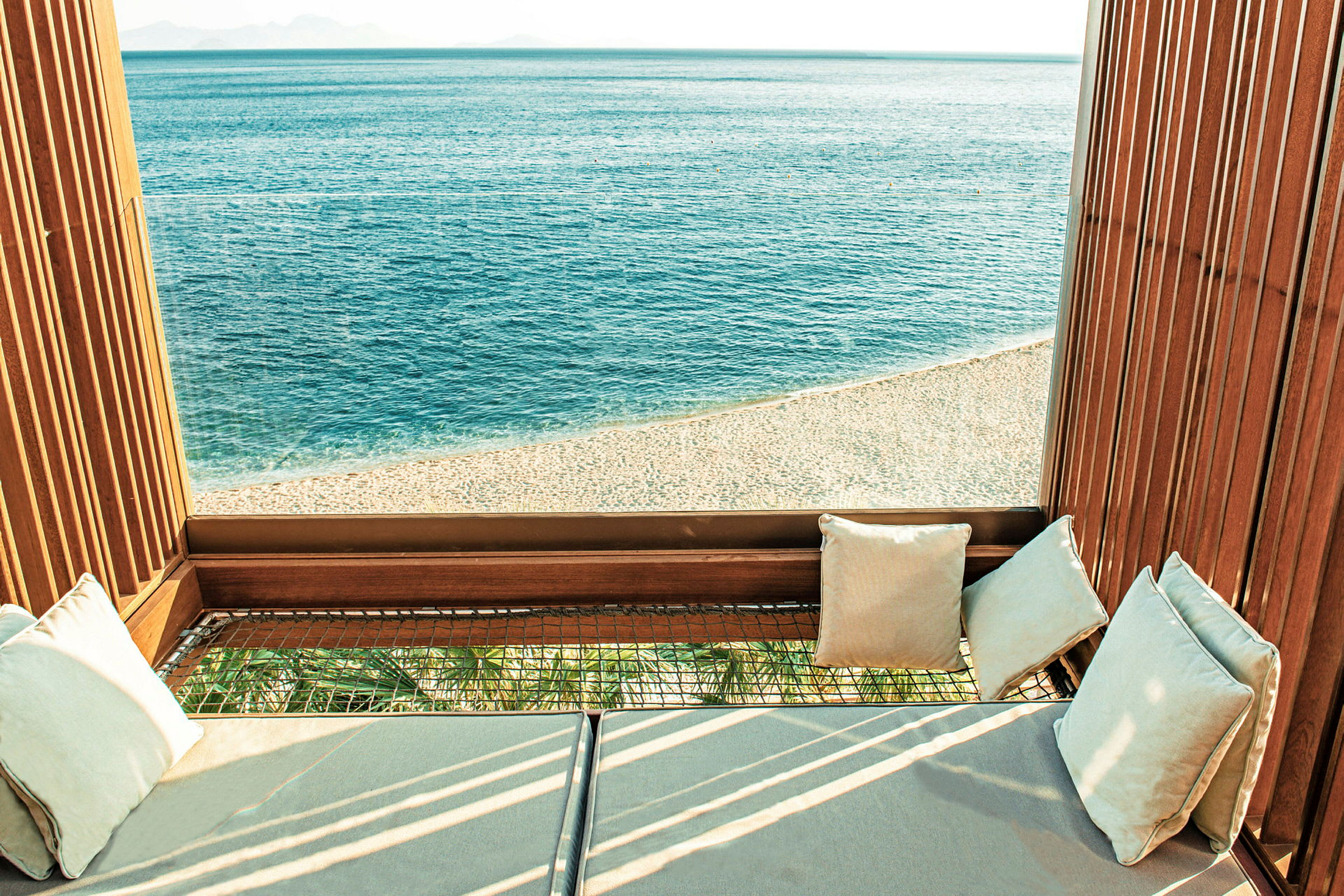 Bilde av en loungeplass med utsikt over en strand og et åpent hav. (AI-generert tekst)
