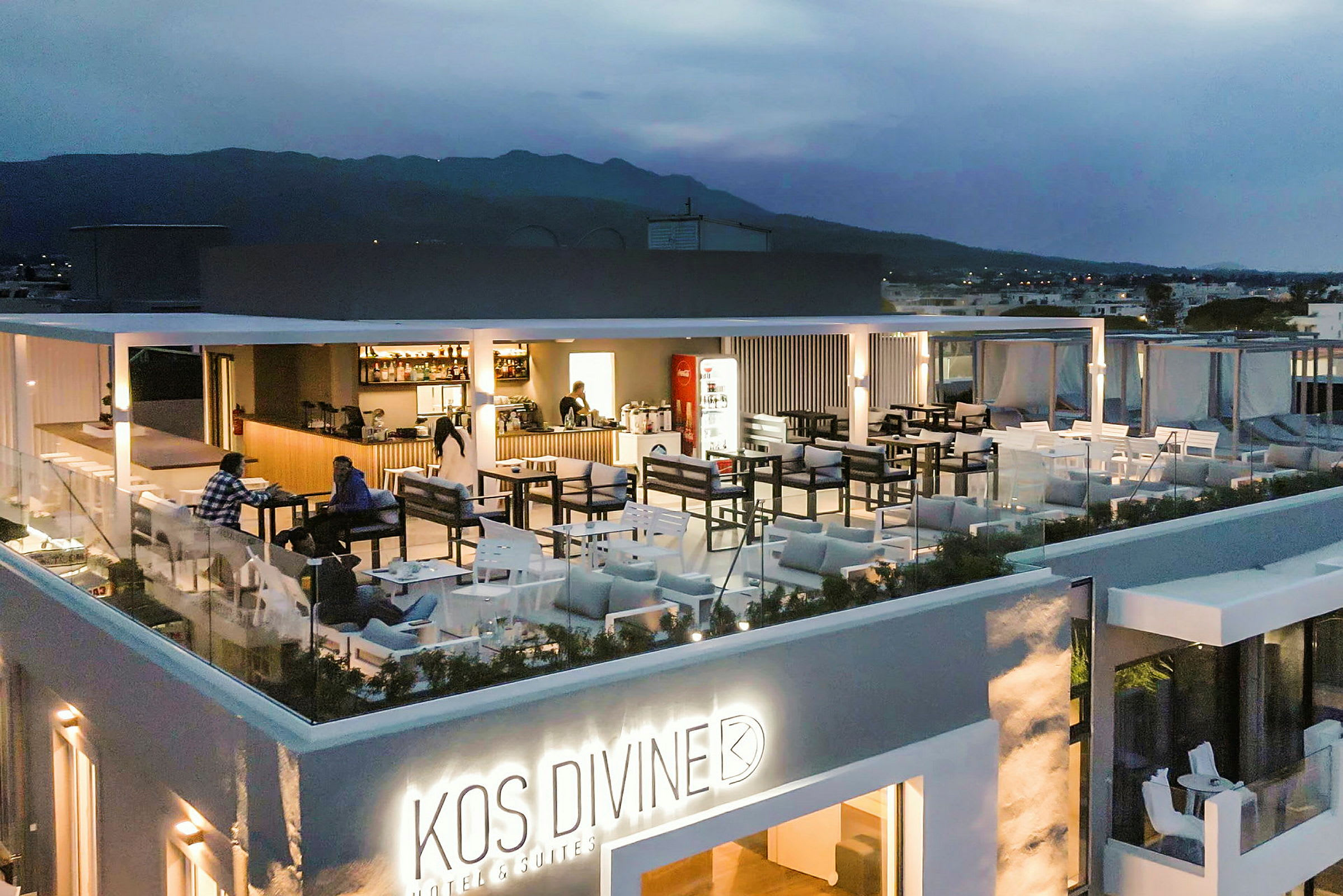 Bilde av en opplyst takrestaurant på et hotell med utemøbler og utsikt over det omkringliggende landskapet. (AI-generert tekst)
