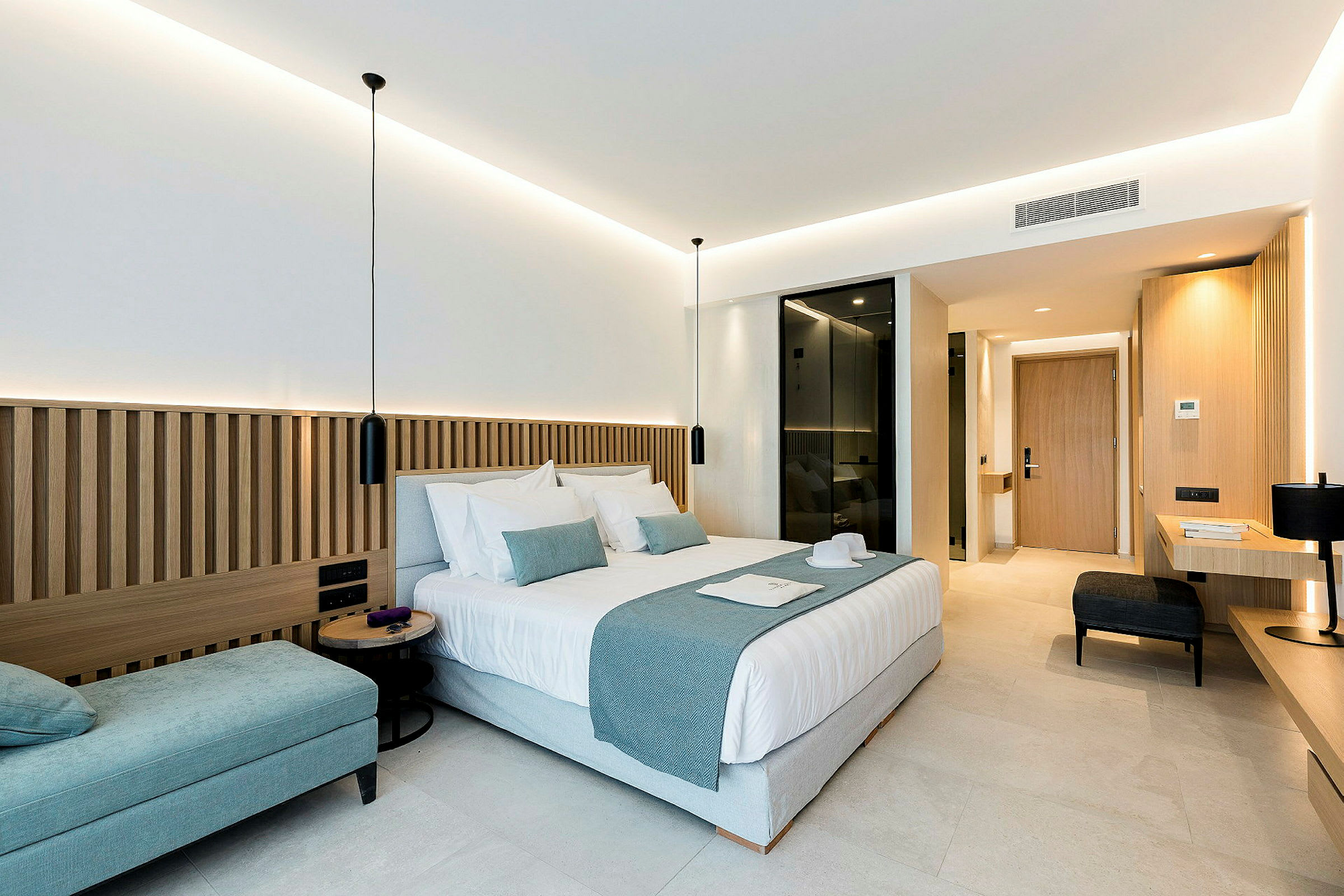 Moderne designet hotellrom med dobbeltseng, sittemøbler og skrivebord. (AI-generert tekst)