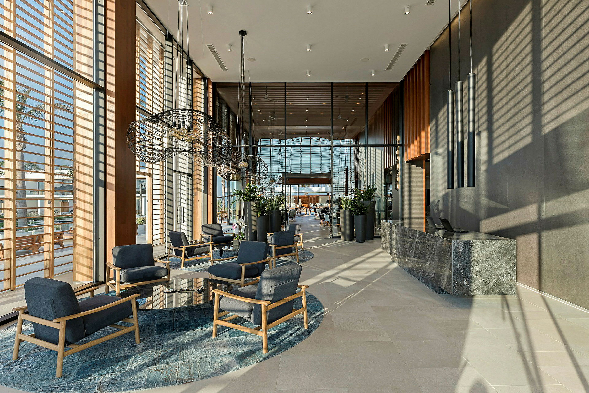 Hotellobby med moderne møbler og store vinduer. (AI-generert tekst)