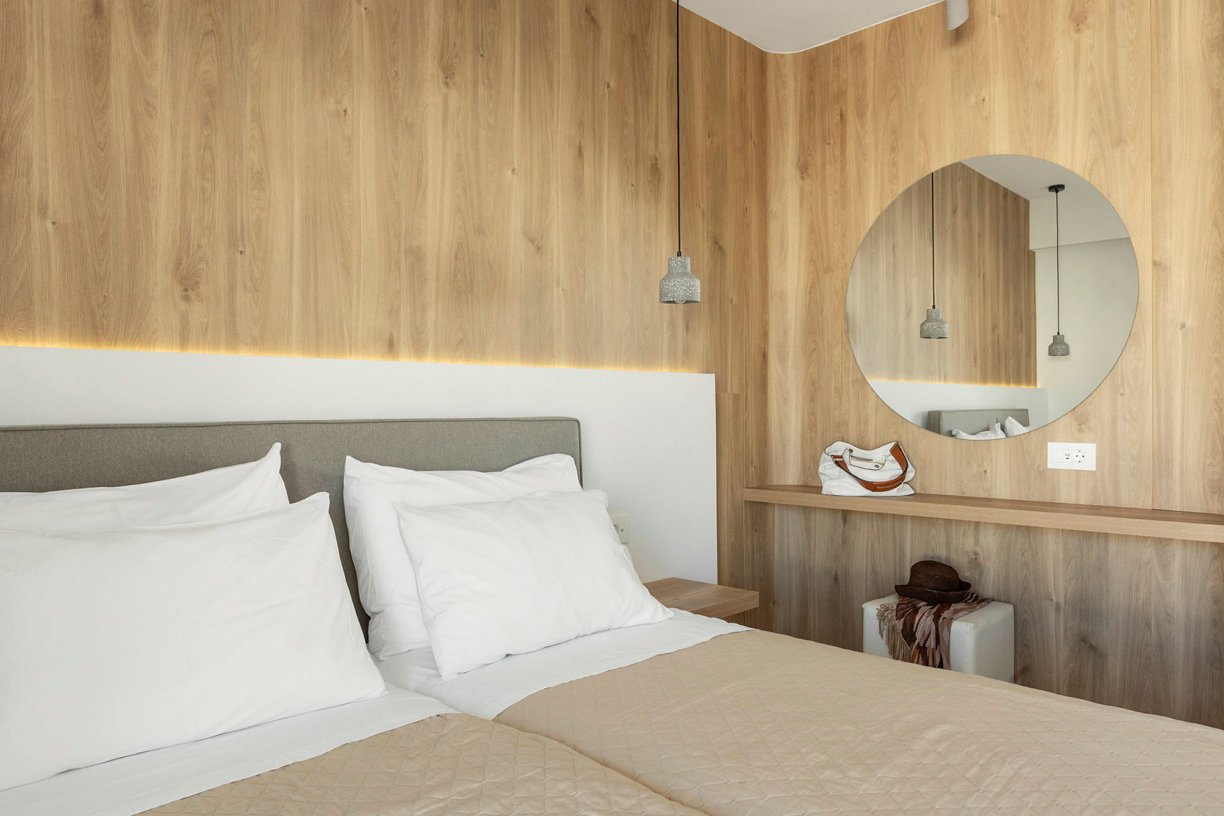 Moderne hotellrom med to senger og trepanel. (AI-generert tekst)