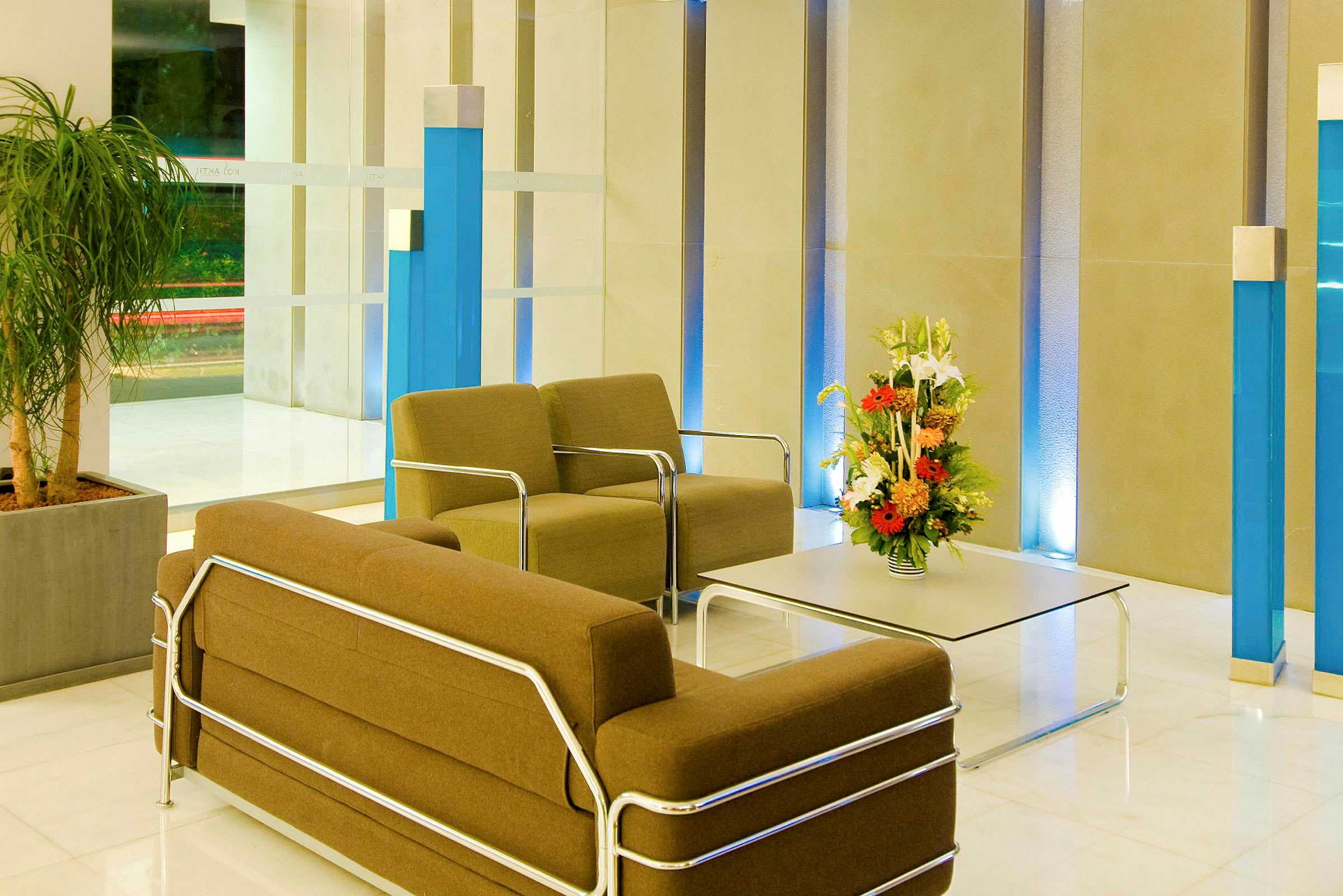 Bilde av en hotellobby med stoler og bord, dekorert med en blomsteroppsats. (AI-generert tekst)