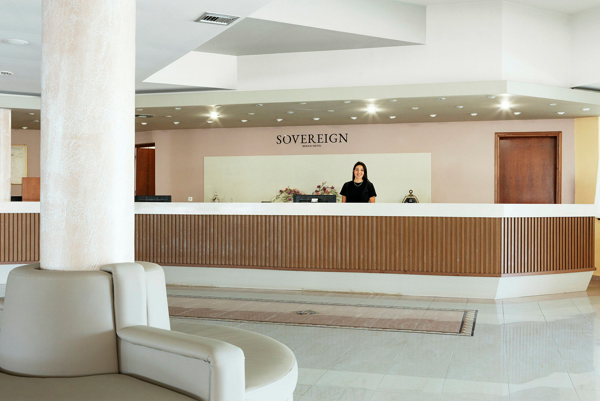 Hotellresepsjon med navnet "Sovereign Beach Hotel" over. (AI-generert tekst)