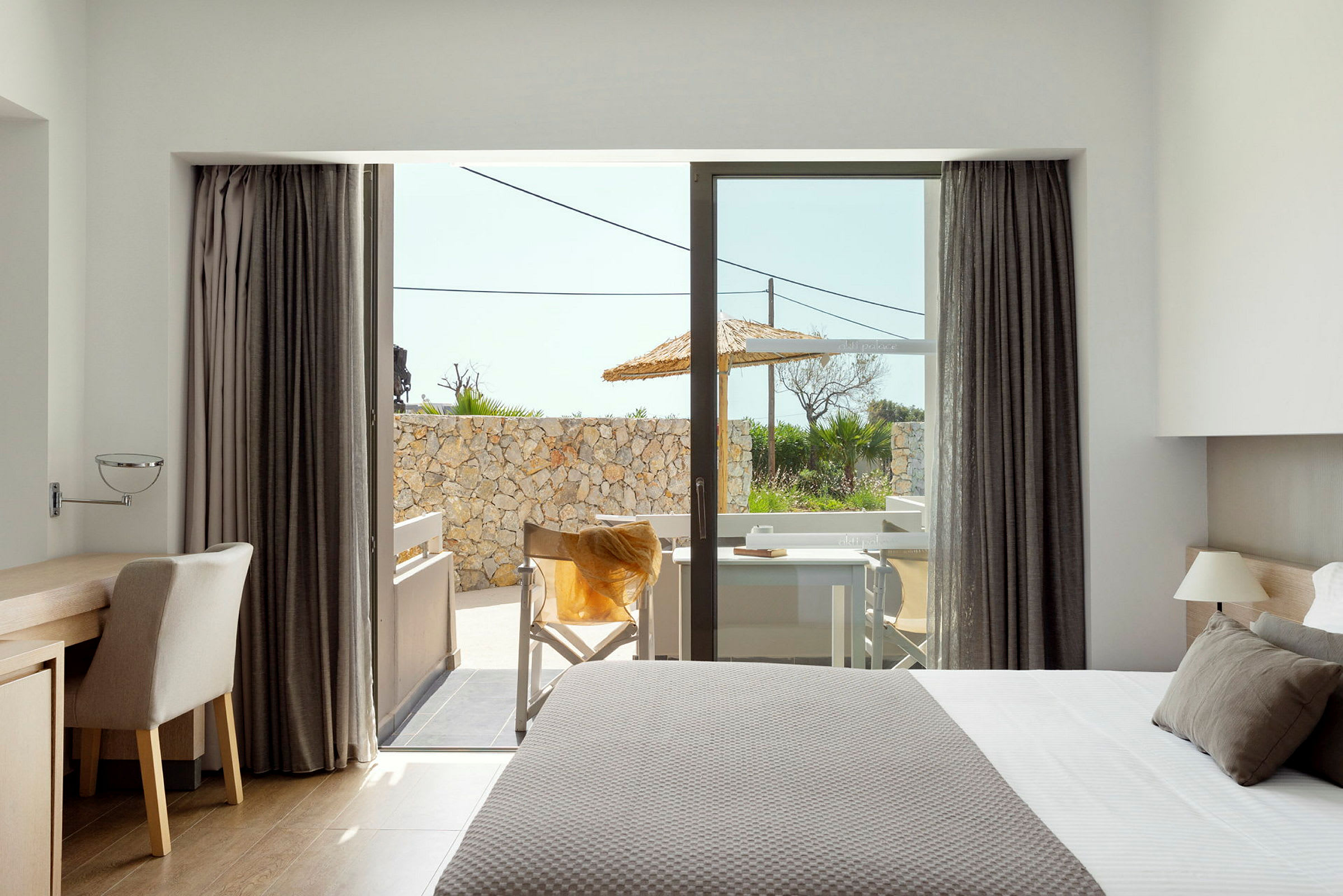 Moderne hotellrom med utsikt over en terrasse. (AI-generert tekst)