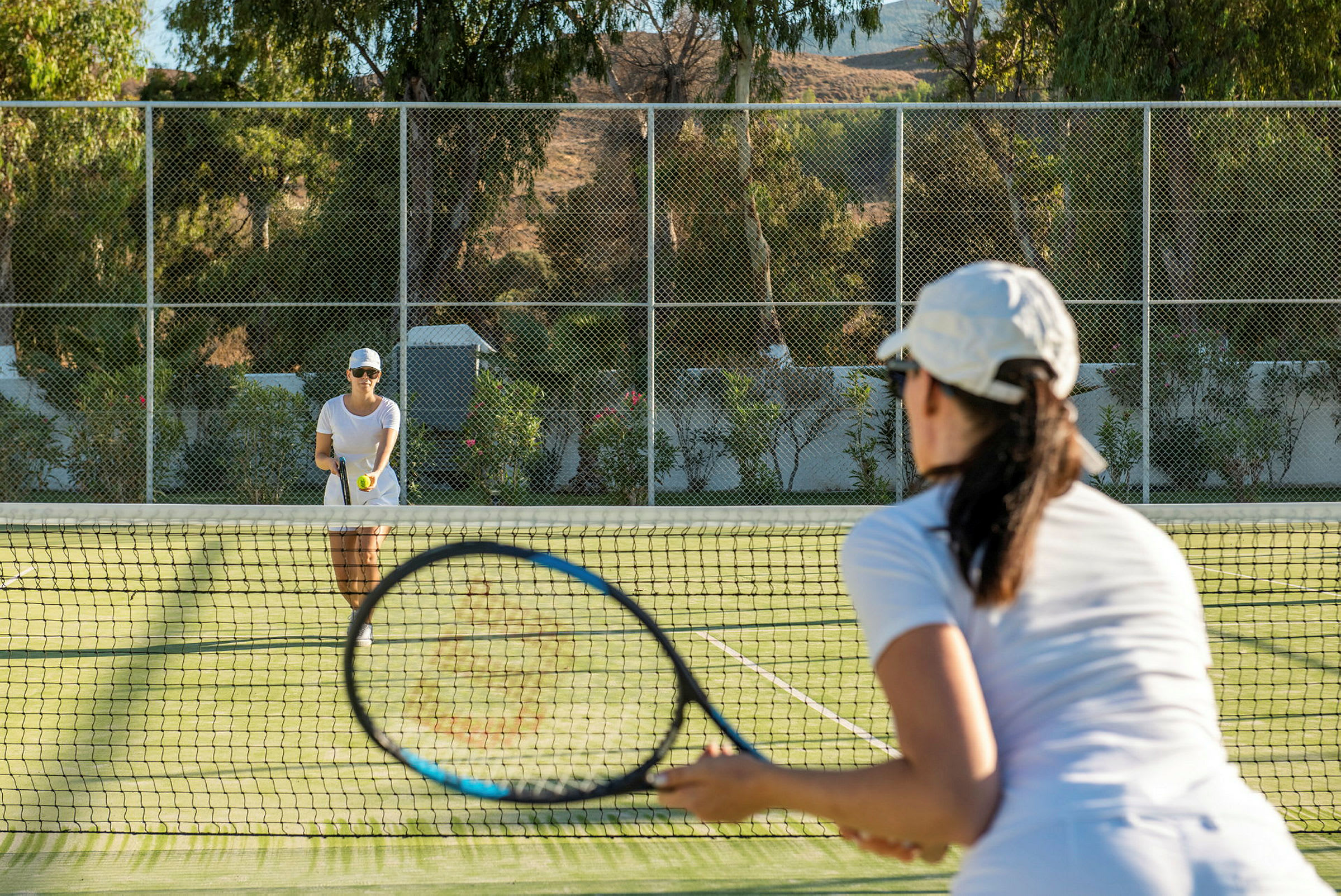 To personer spiller tennis på en gressbane. (AI-generert tekst)