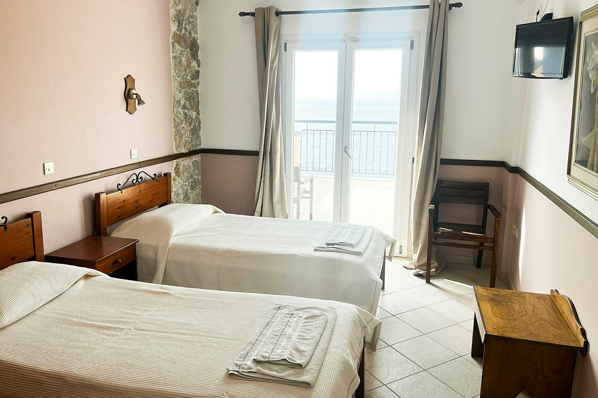 Hotellrom med to enkeltsenger, et vindu med havutsikt. (AI-generert tekst)