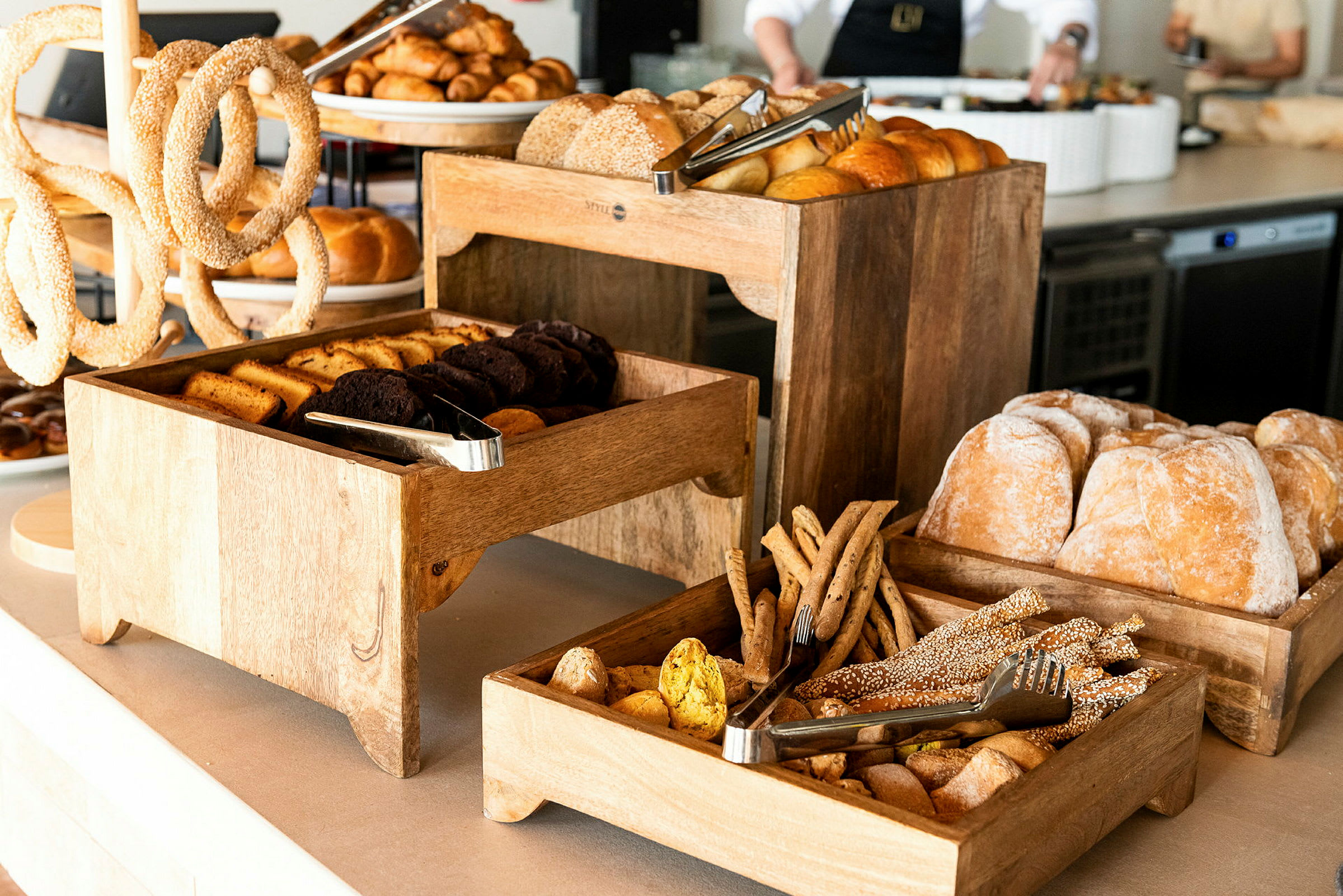 En buffet med forskjellige typer brød og bakverk presentert i trebrett. (AI-generert tekst)