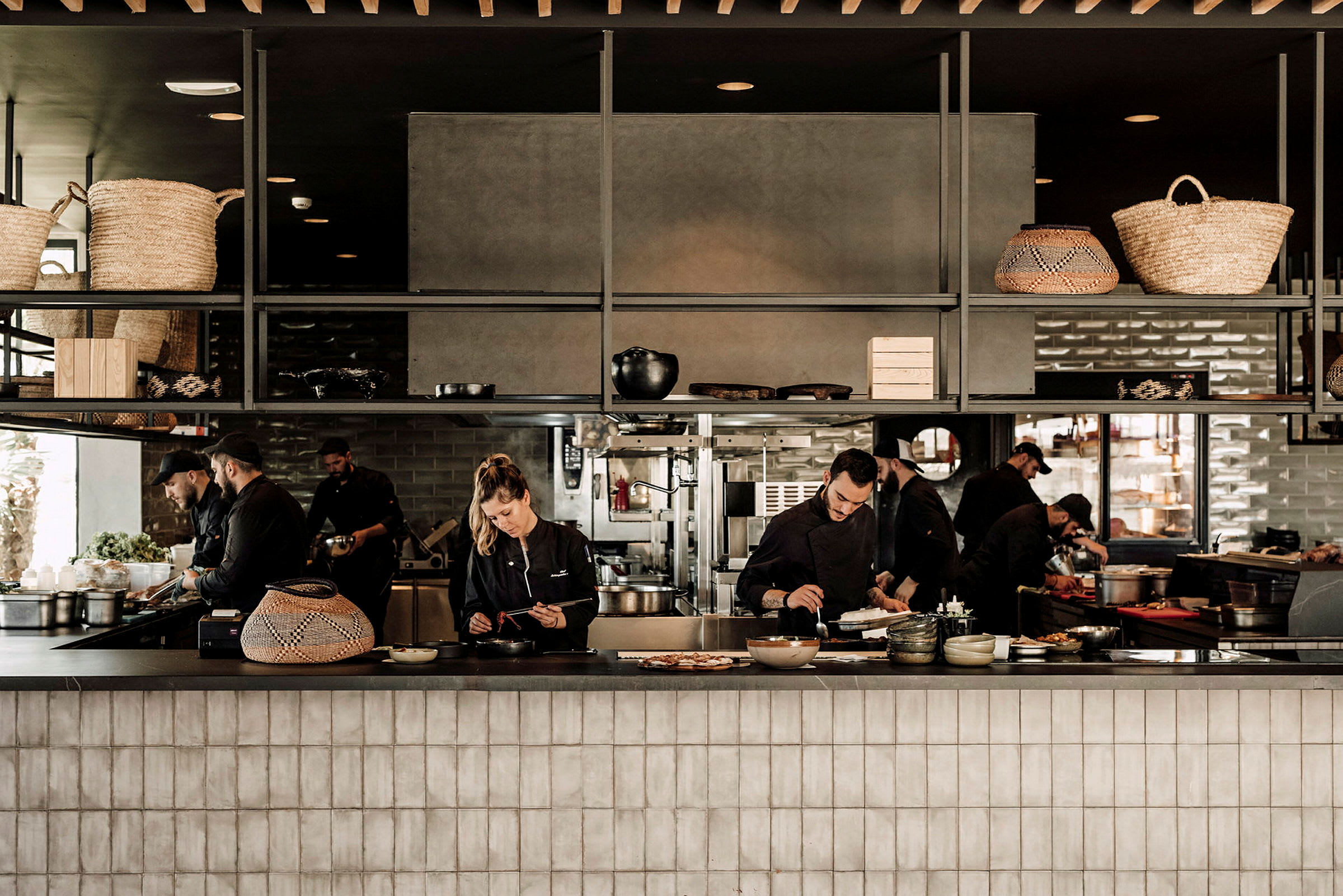 En restaurantkjøkkeninteriør med kokker som tilbereder mat. (AI-generert tekst)