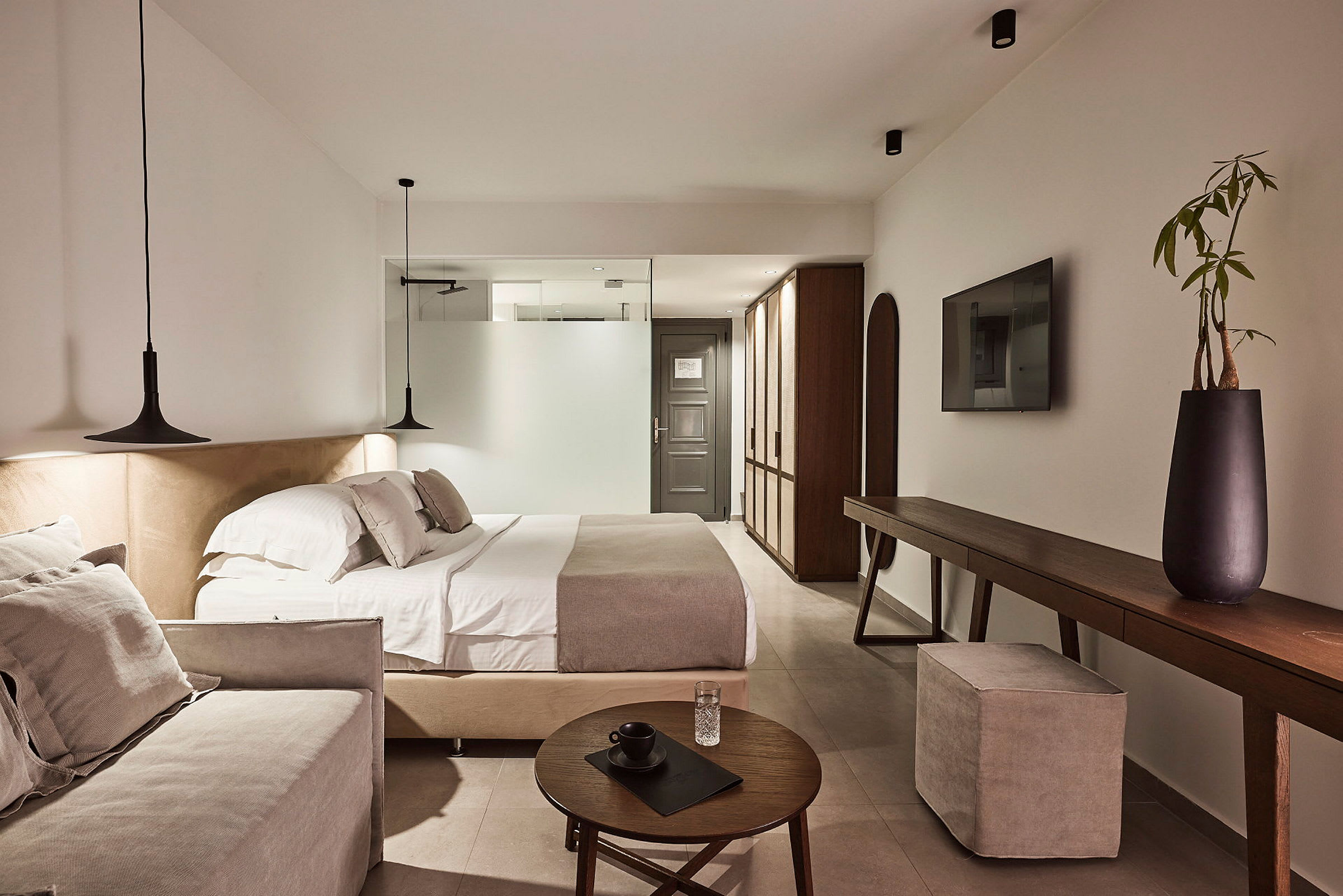 Et moderne hotellrom med dobbeltseng, sofa og elegant interiør. (AI-generert tekst)