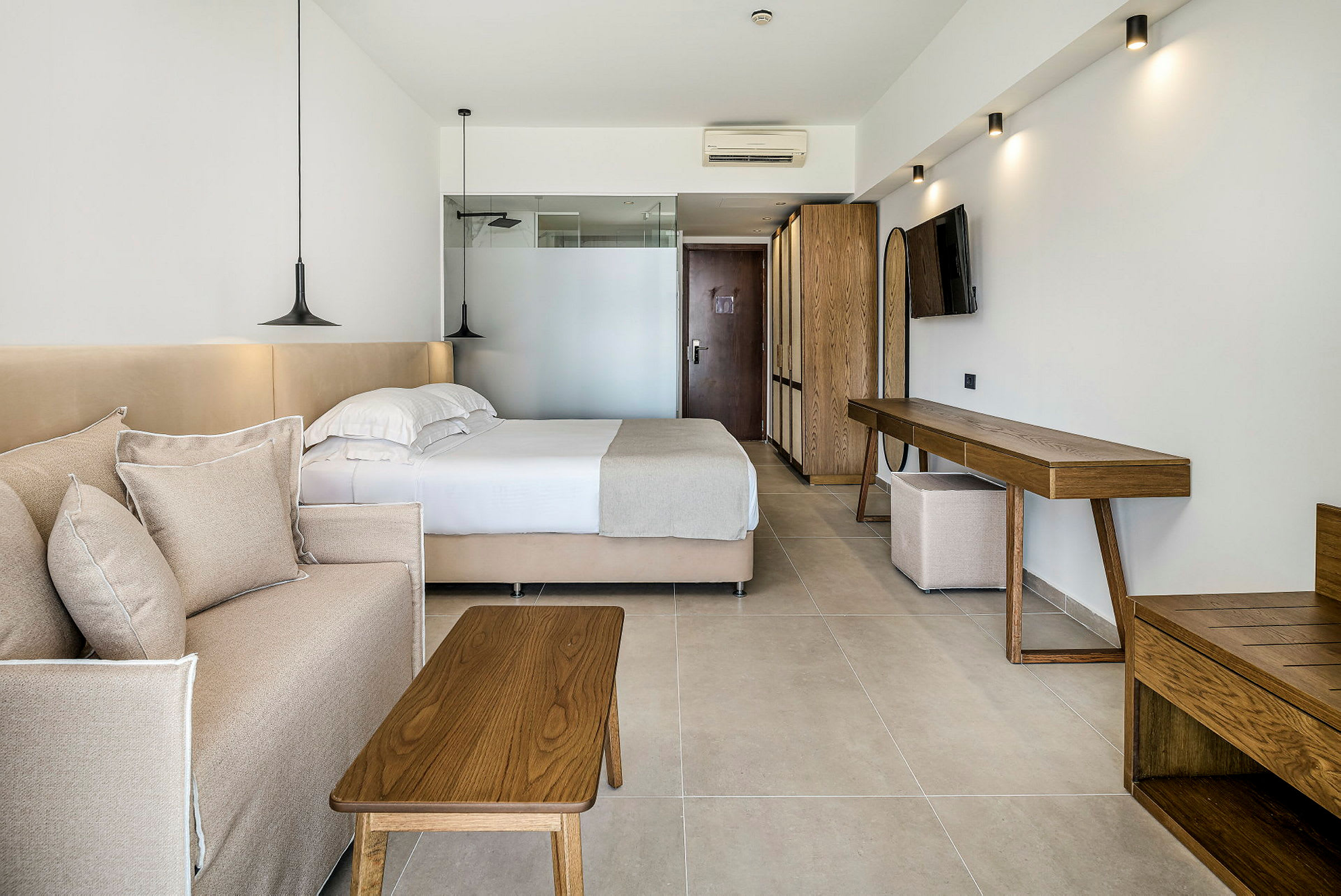 Et hotellrom med en seng, en sofa og tremøbler. (AI-generert tekst)