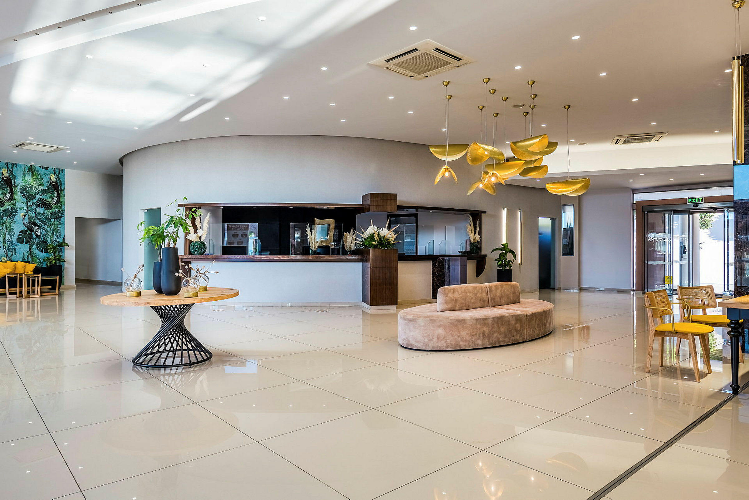 Lys hotellobby med moderne innredning, sofaer og bord. (AI-generert tekst)
