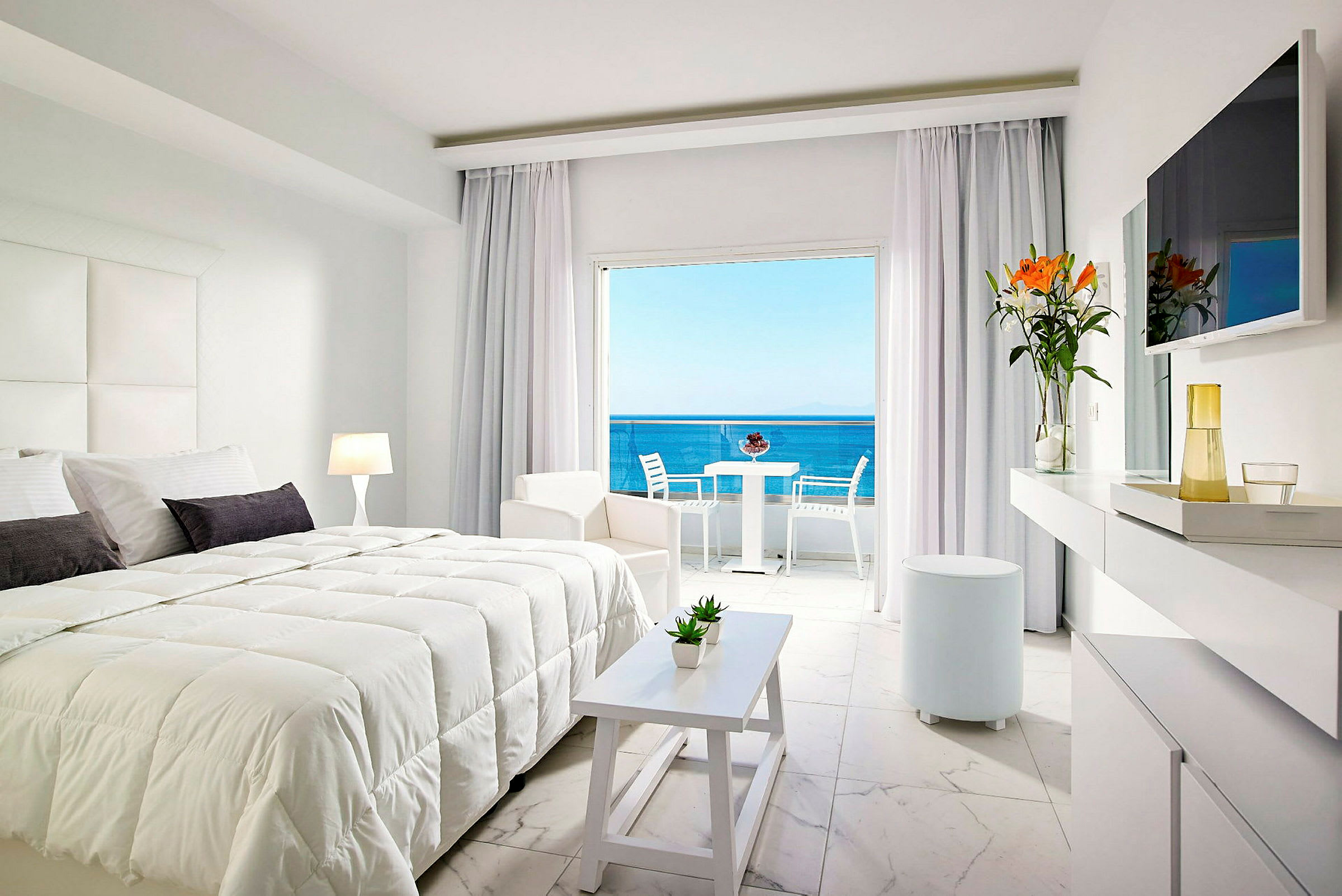 Moderne hotellrom med dobbeltseng, lyse møbler og utsikt over havet. (AI-generert tekst)