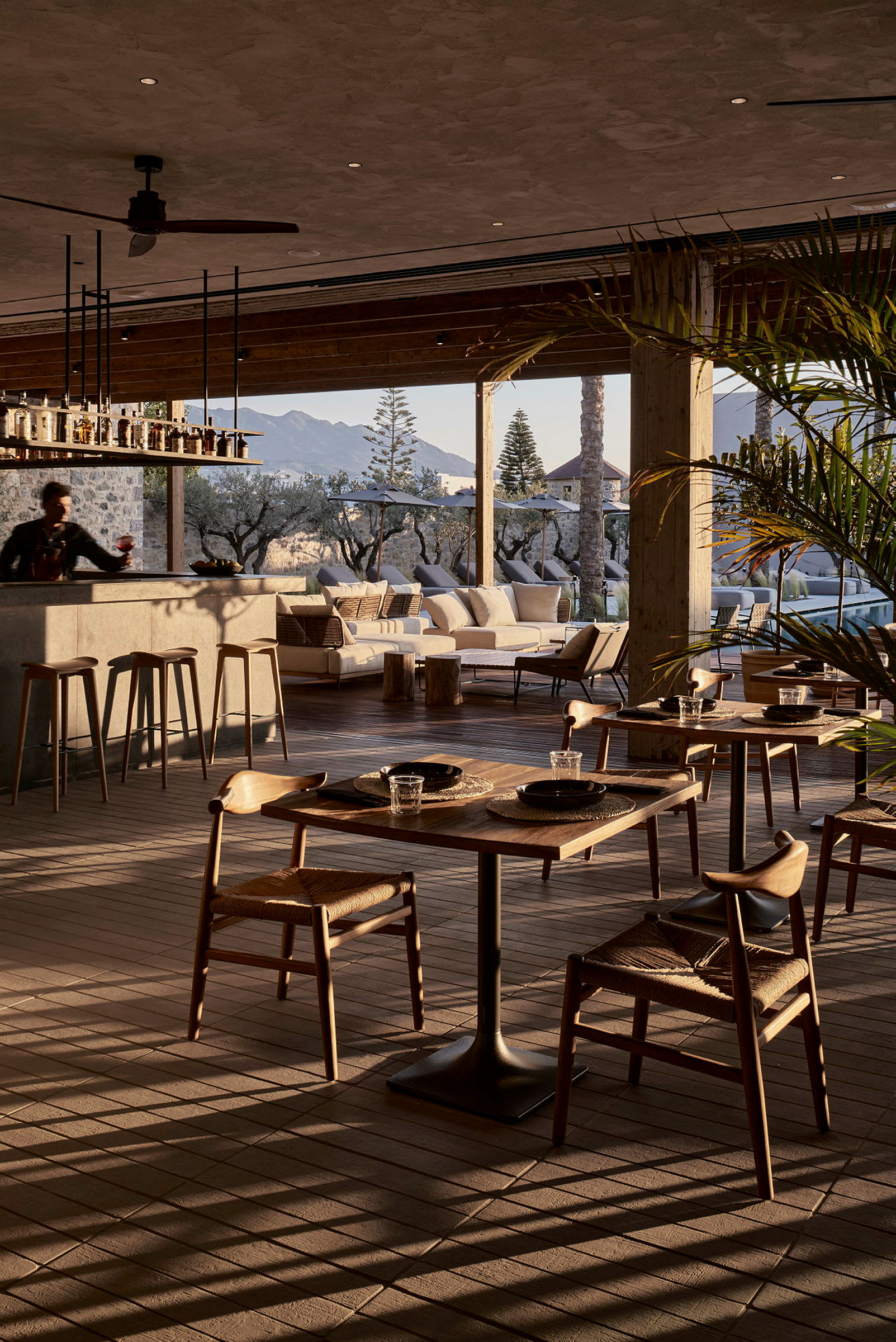En elegant restaurant med utsikt over et utendørsområde og fjell i bakgrunnen. (AI-generert tekst)