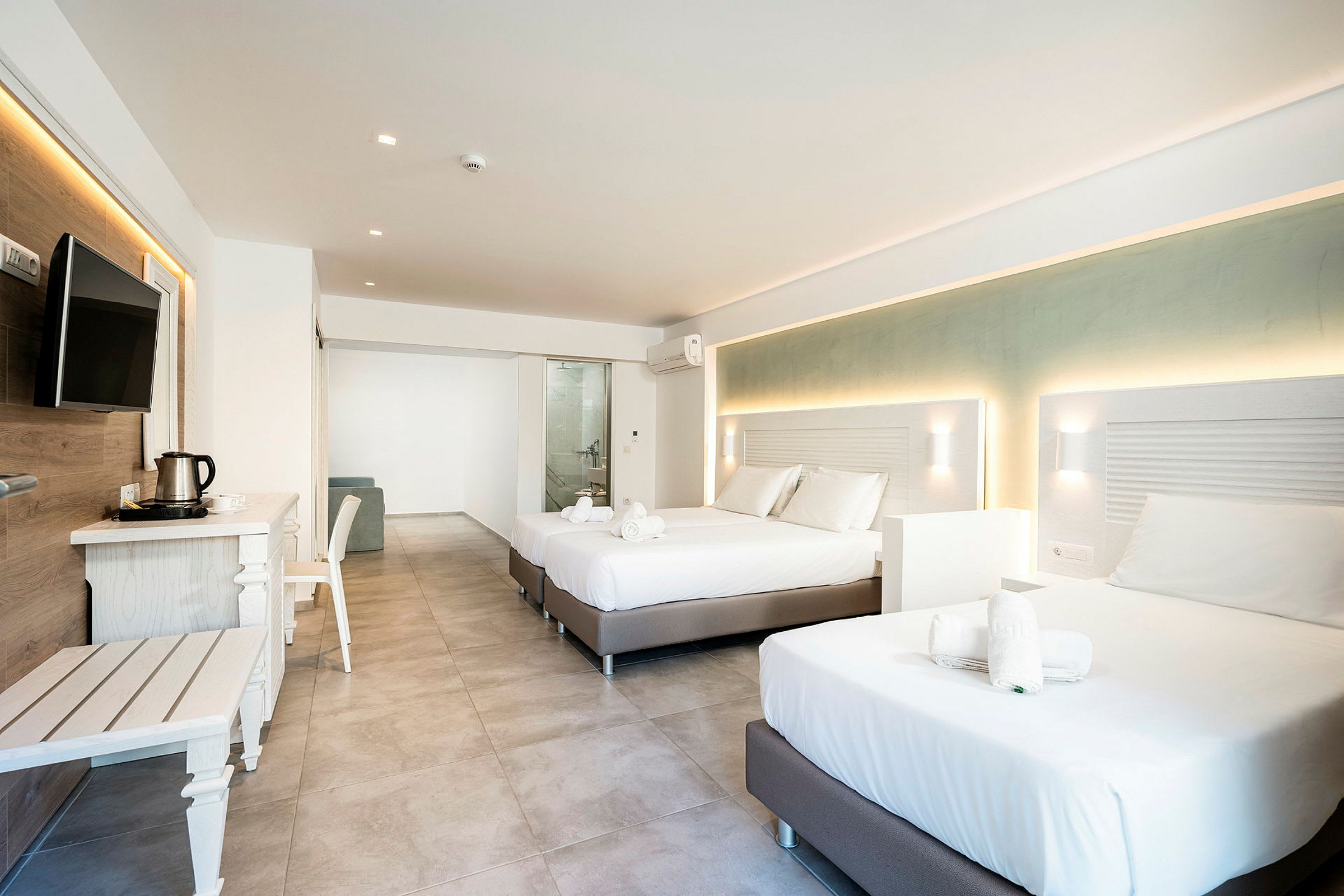 Moderne hotellrom med to dobbeltsenger, møbler og utsikt mot badeværelset. (AI-generert tekst)