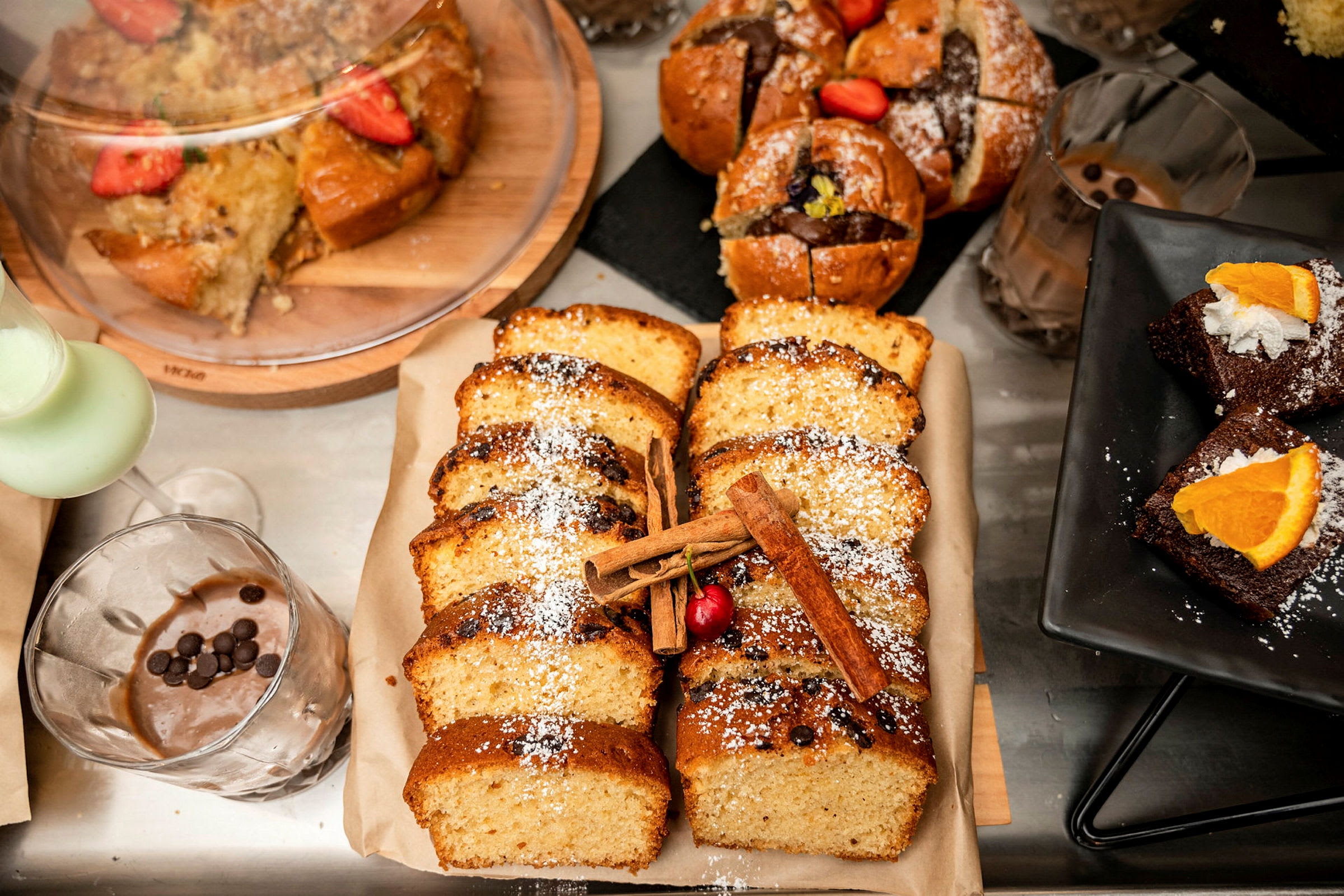 Assorterte bakverk, inkludert skiver av kaker, muffins og brownies med pynt. (AI-generert tekst)