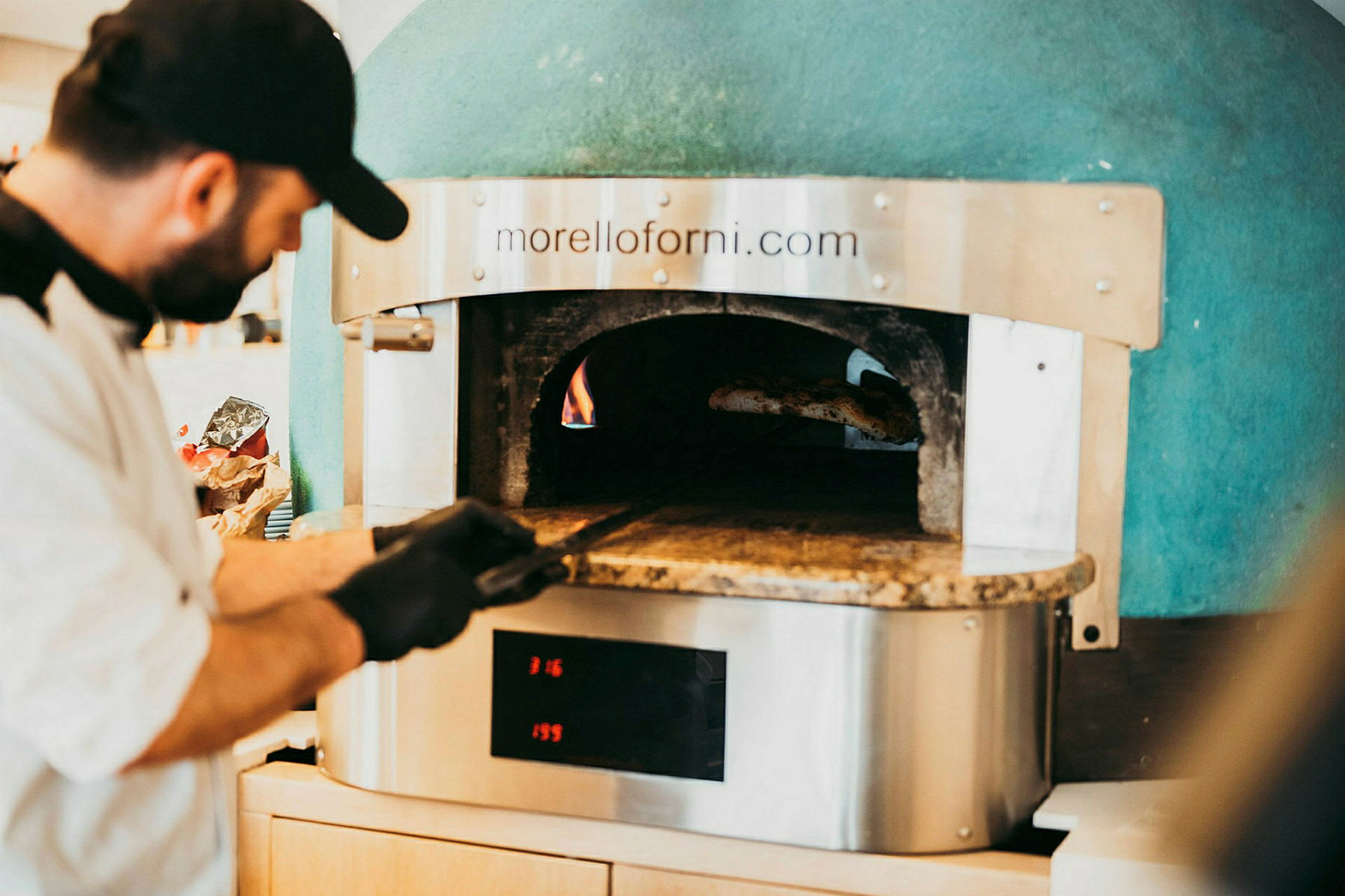 En vedfyrt ovn med ild og pizzaspade. (AI-generert tekst)