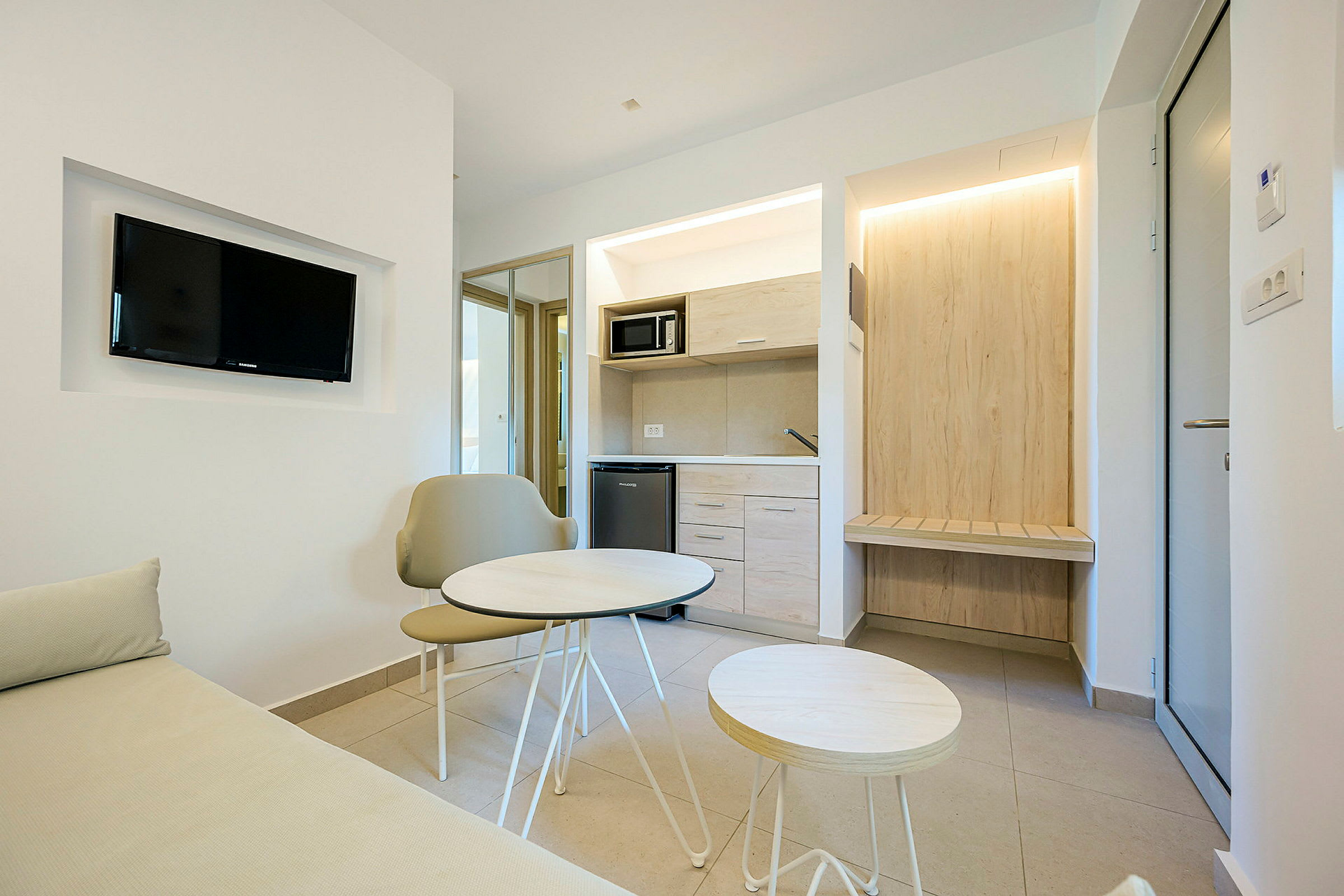 Et moderne hotellrom med en liten sittegruppe og tekjøkken. (AI-generert tekst)