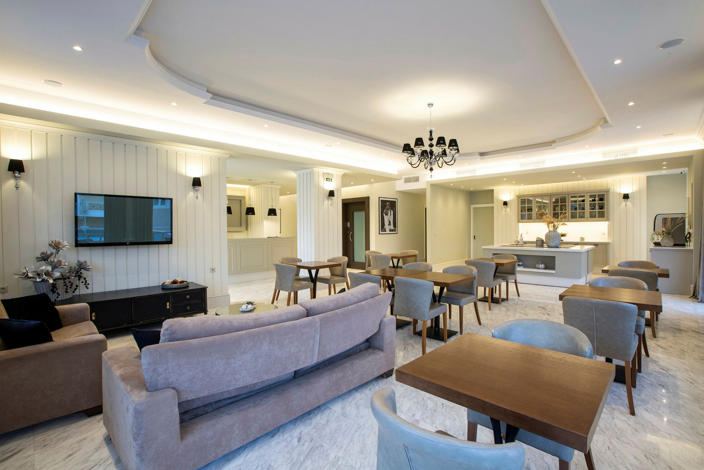 En romslig innendørslounge med sittegrupper og et kjøkkenområde i elegant moderne stil. (AI-generert tekst)