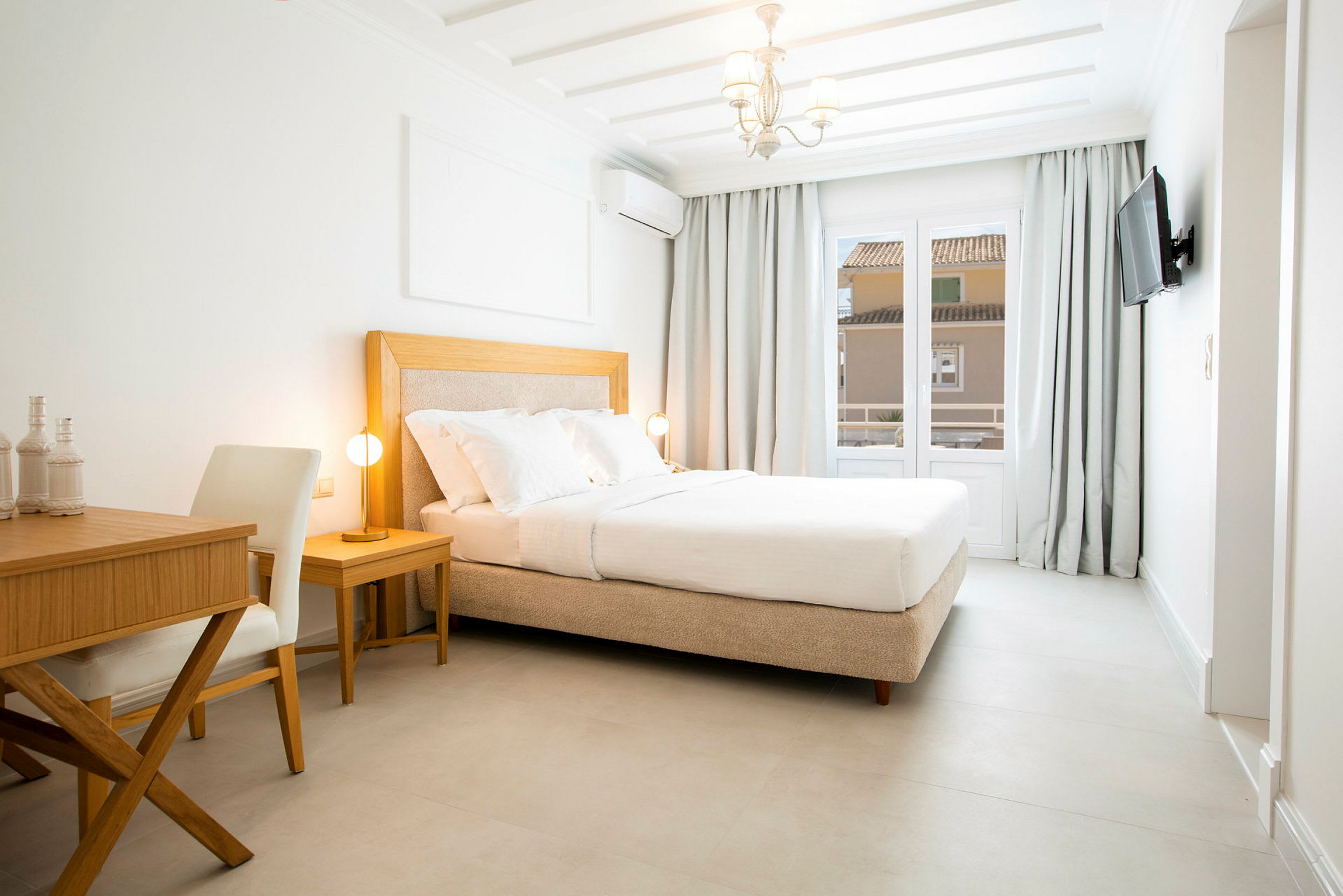 Et lyst hotellrom med en komfortabel dobbeltseng, et skrivebord og en stol. (AI-generert tekst)