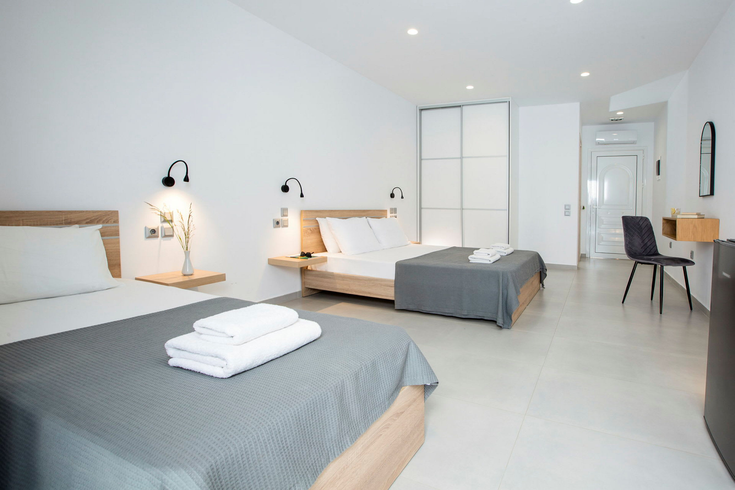 Hotellrom med to senger og moderne innredning. (AI-generert tekst)