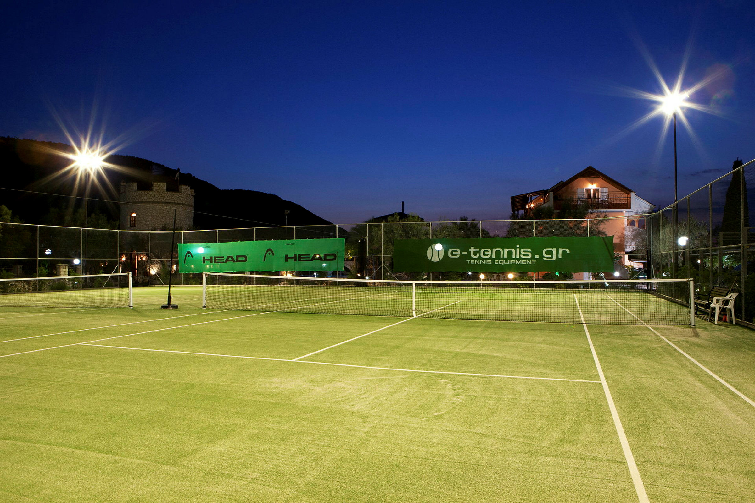 En utendørs tennisbane med belysning ved skumring. (AI-generert tekst)