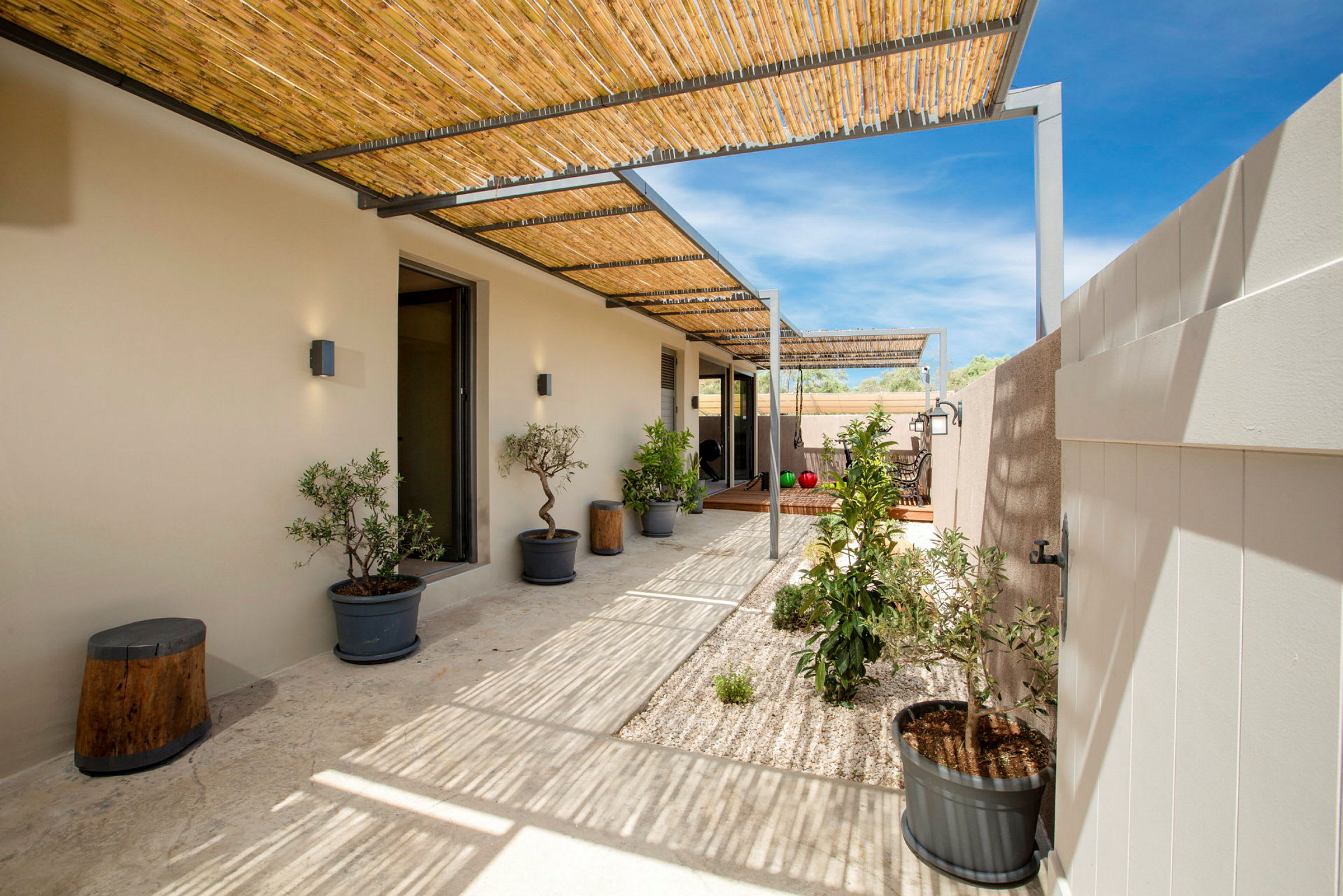 En utendørs terrasse med pergola og planter i potter. (AI-generert tekst)