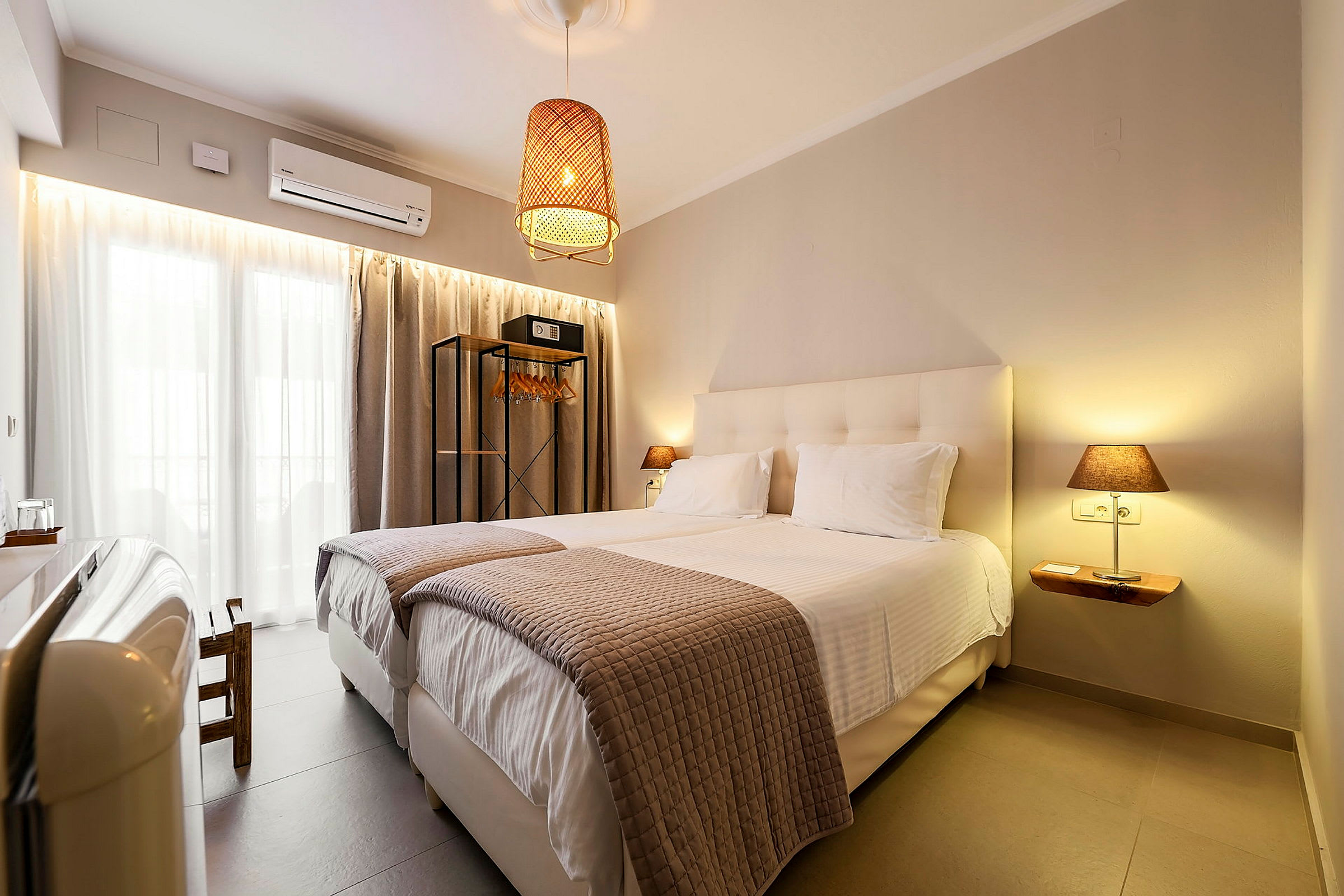 Et hotellrom med to enkeltsenger, moderne interiør og en hengende lampe. (AI-generert tekst)
