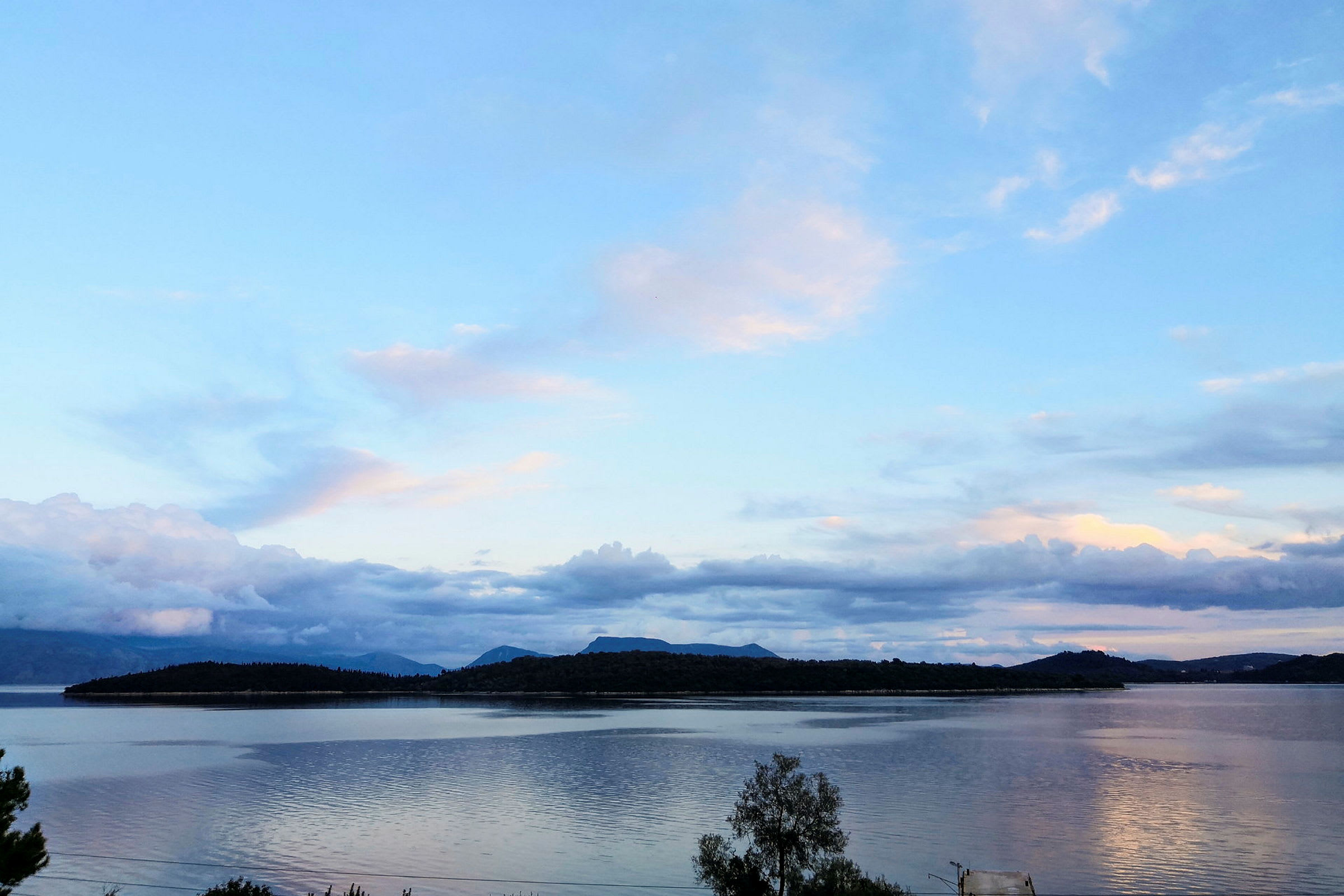 En utsikt over en innsjø med fjell i bakgrunnen under en klar himmel. (AI-generert tekst)