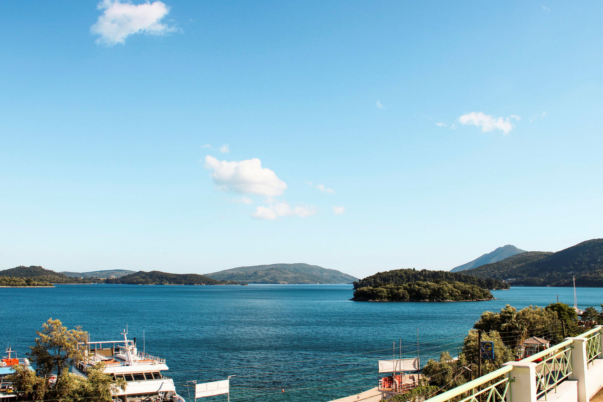 Utsikt over en havbukt med båter og øyer, omgitt av fjell. (AI-generert tekst)