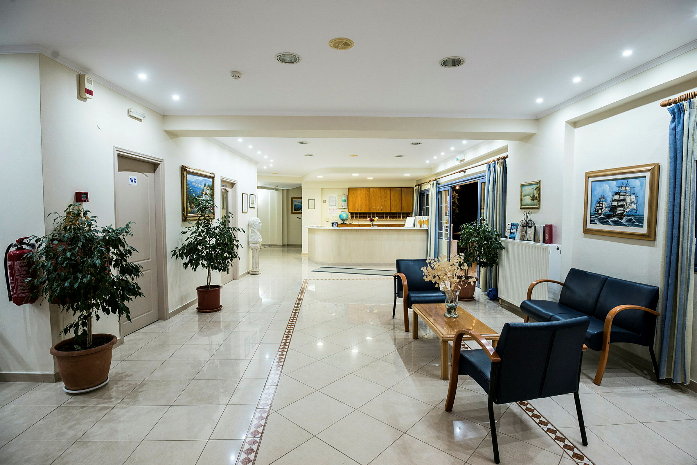 Bilde av en hotellobby med resepsjon, sittegruppe og dekorative planter. (AI-generert tekst)