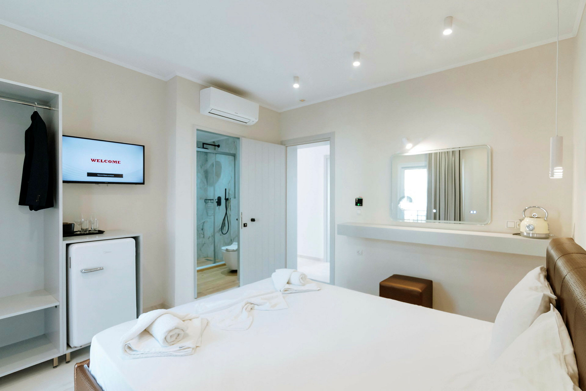 Moderne hotellrom med seng, speil og bad. (AI-generert tekst)