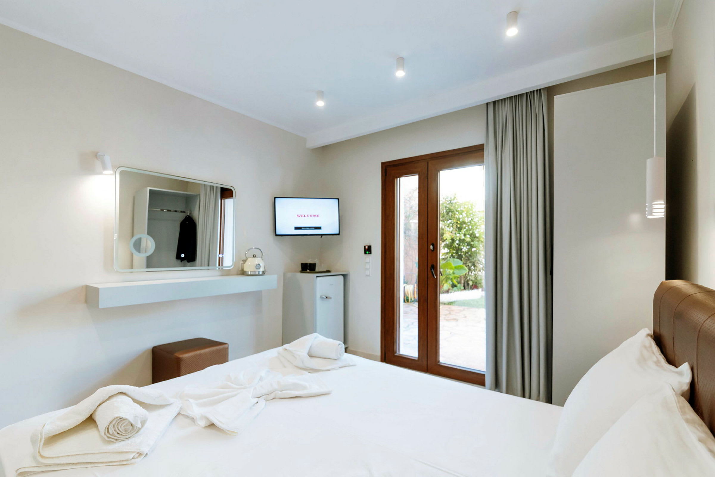 Moderne hotellrom med en dobbeltseng og utsikt mot hagen. (AI-generert tekst)