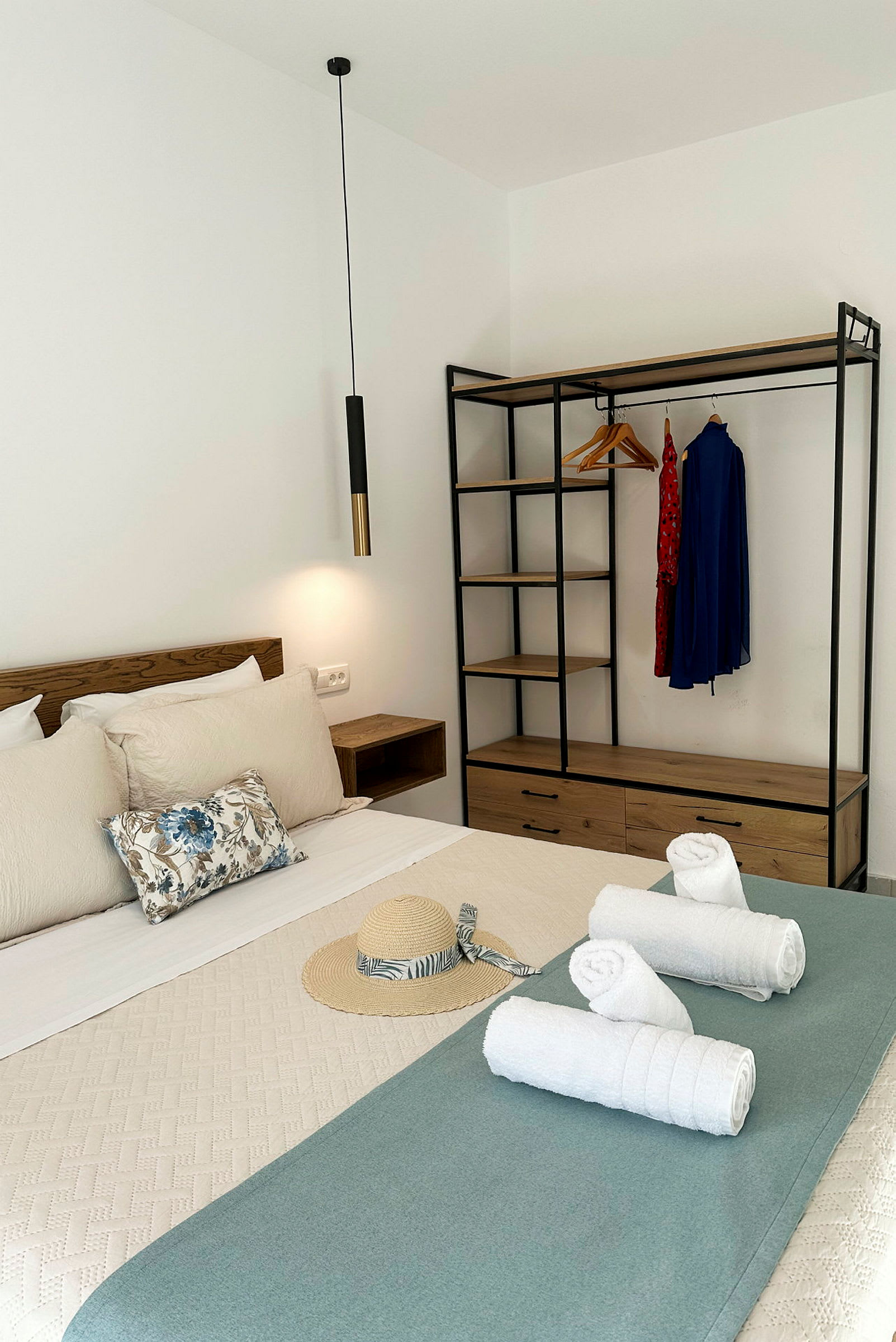 Et hotellrom med seng, håndklær og garderobe. (AI-generert tekst)