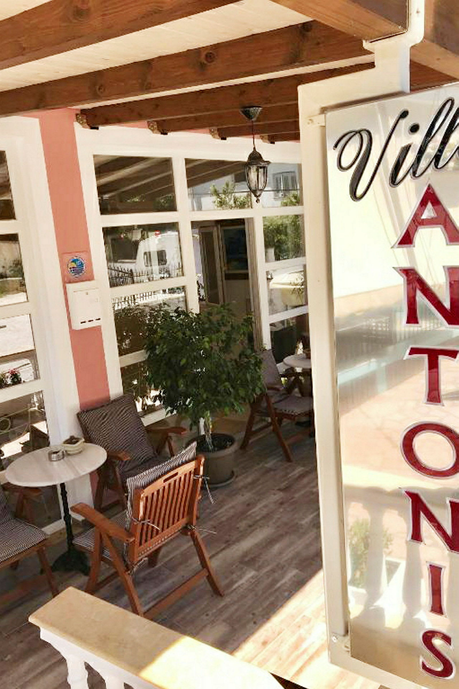 Inngangsområdet til Villa Antonis med sittegruppe og dekorasjoner. (AI-generert tekst)