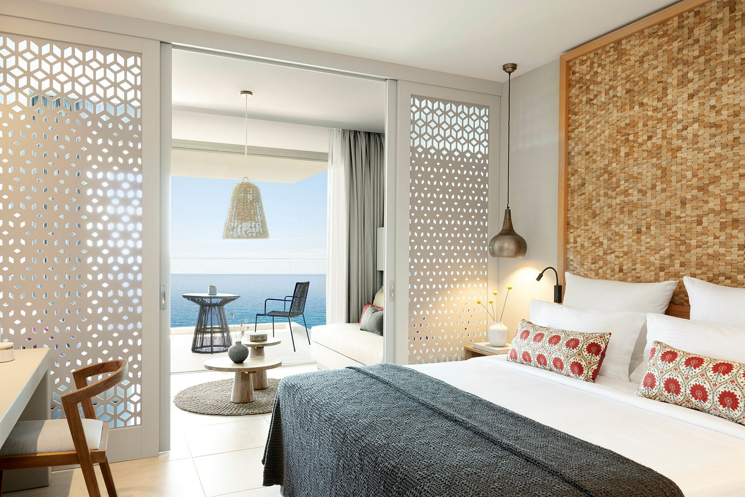 Moderne innredet hotellrom med utsikt over havet fra en møblert balkong. (AI-generert tekst)