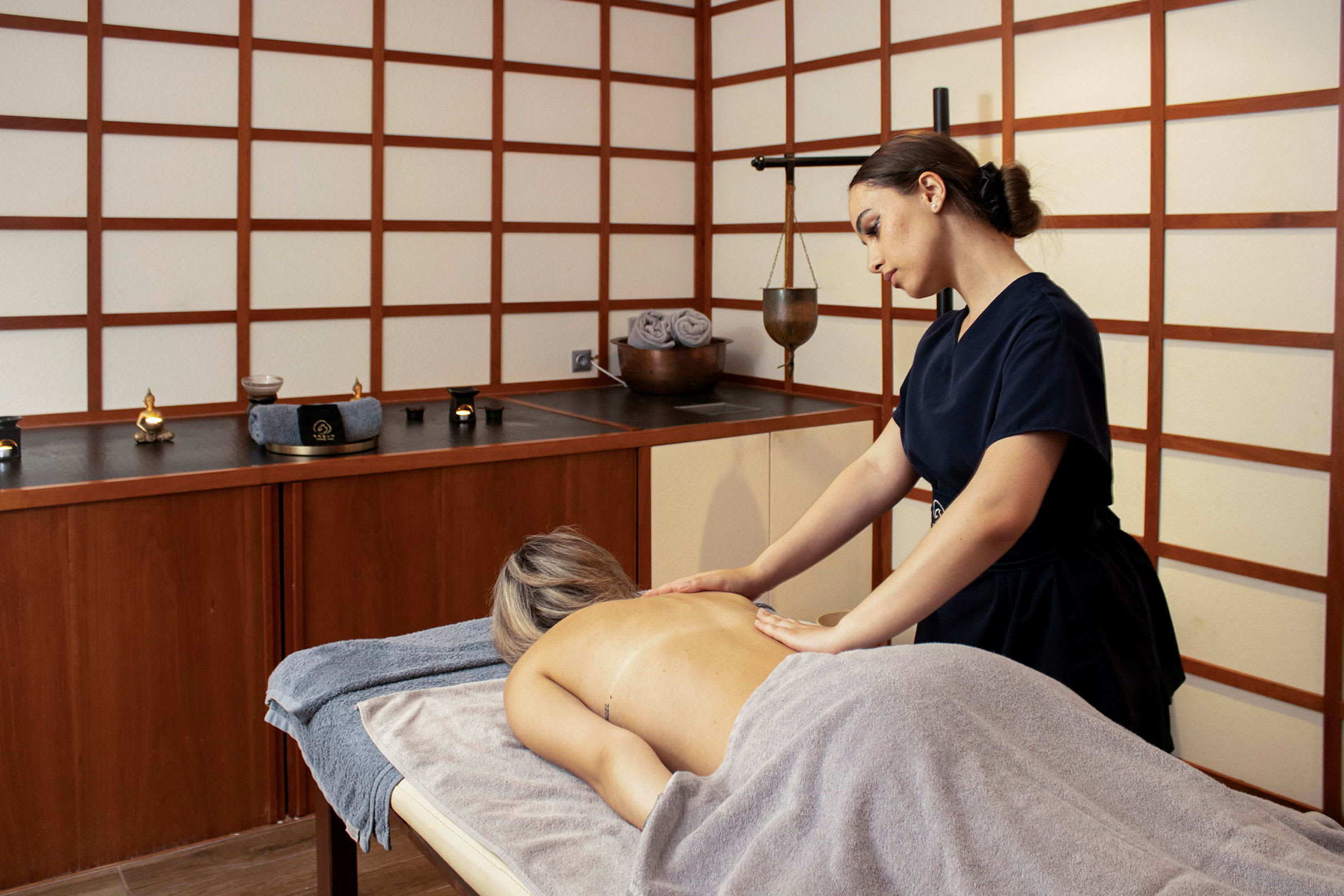 En person får massasje på et spa med asiatisk inspirert innredning. (AI-generert tekst)