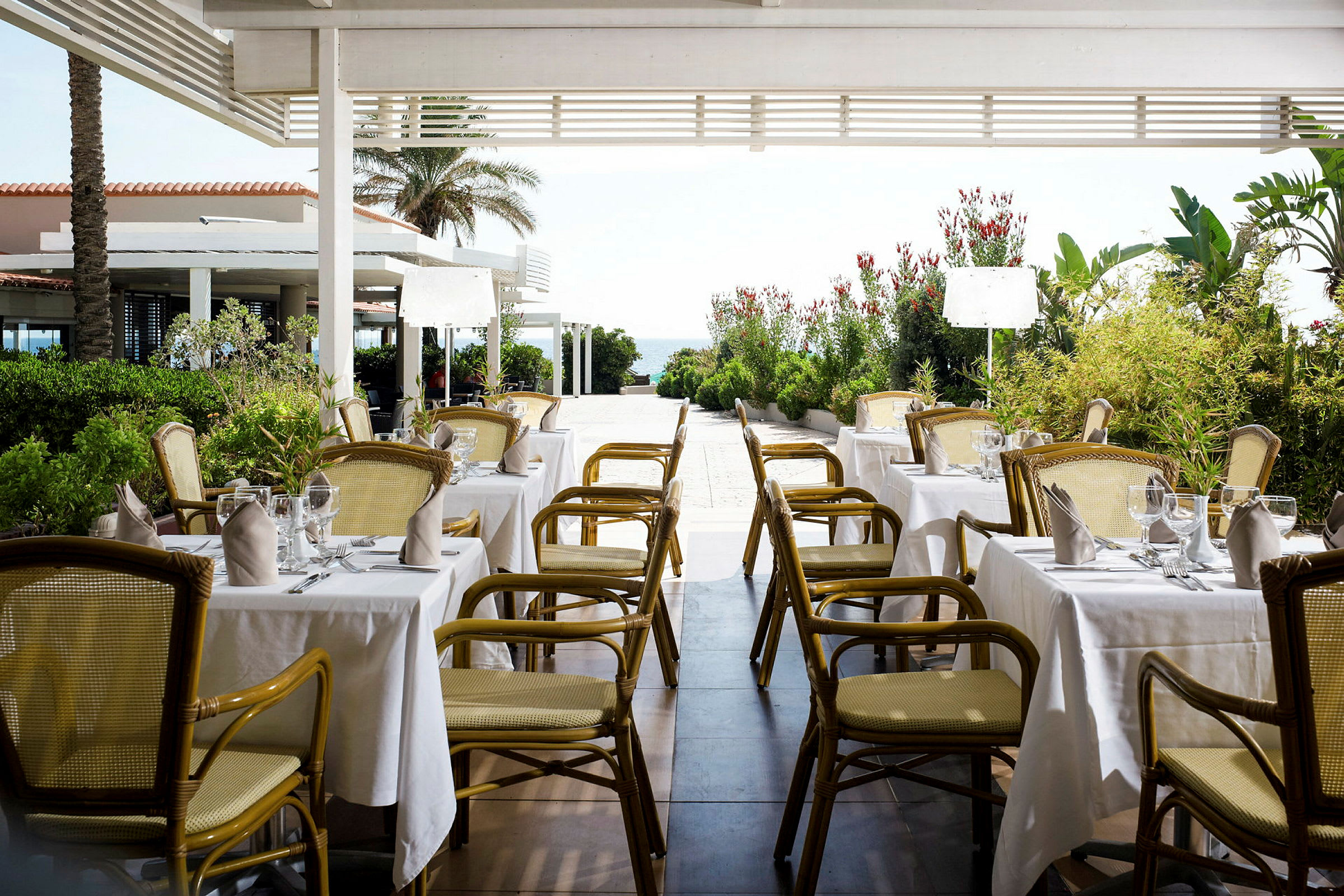Restaurant med dekkede bord under en pergola. (AI-generert tekst)