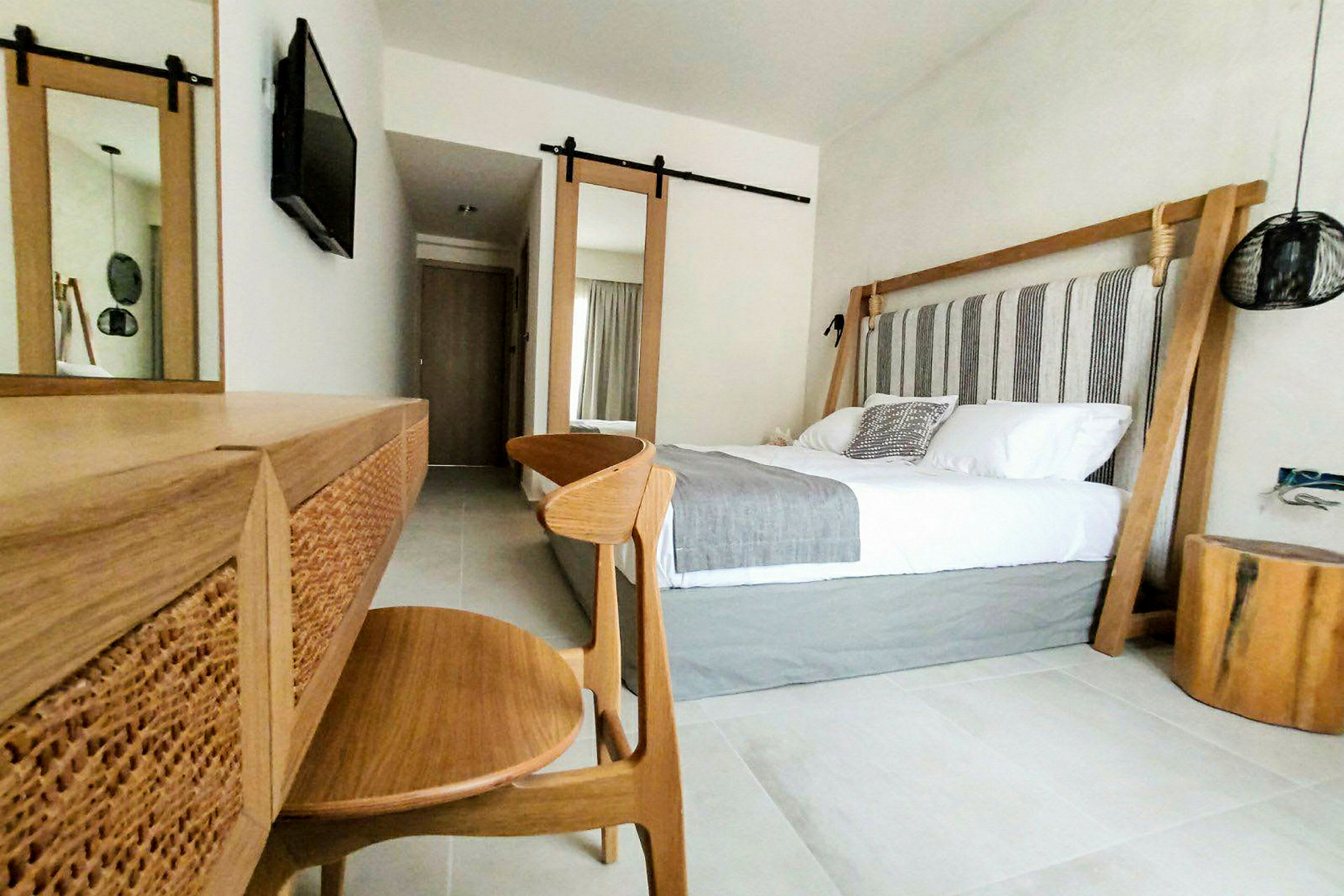 Moderne hotellrominteriør med dobbeltseng og treinteriør. (AI-generert tekst)