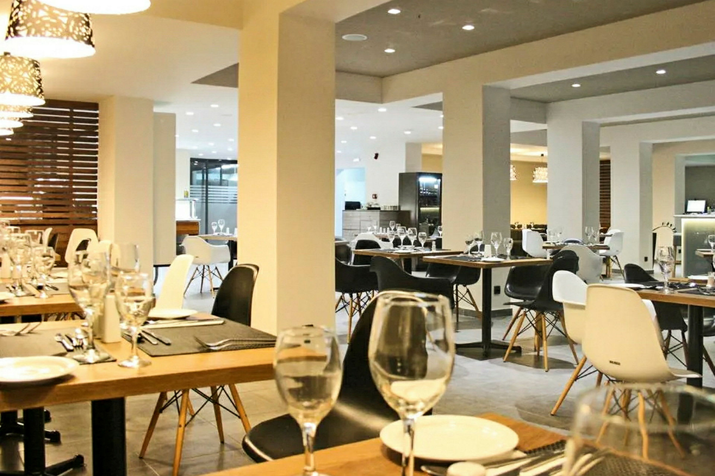 Bilde av et moderne restaurantinteriør med dekkede bord og elegant belysning. (AI-generert tekst)