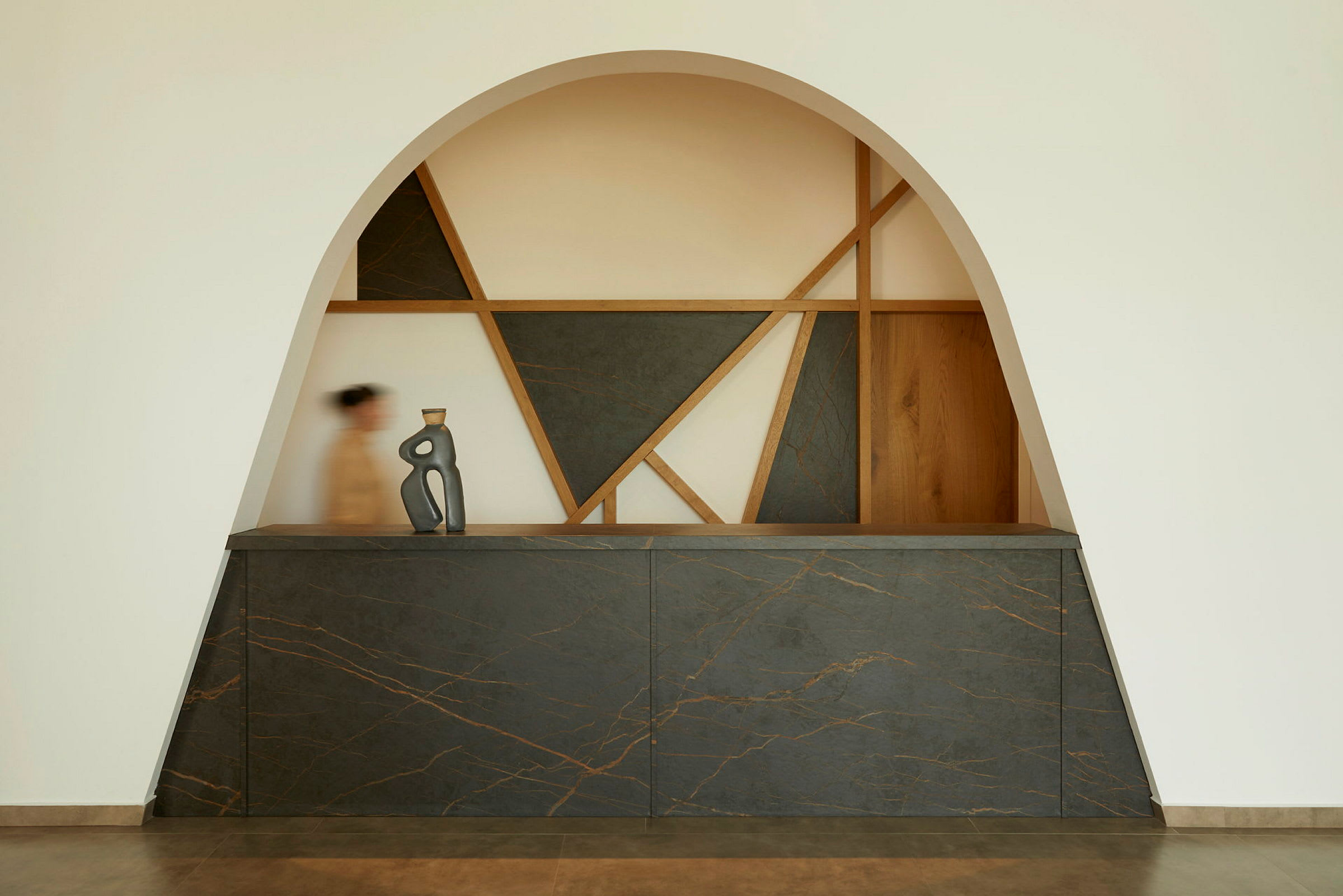 En resepsjon med moderne design, geometriske former og en kunstnerisk skulptur på disken. (AI-generert tekst)