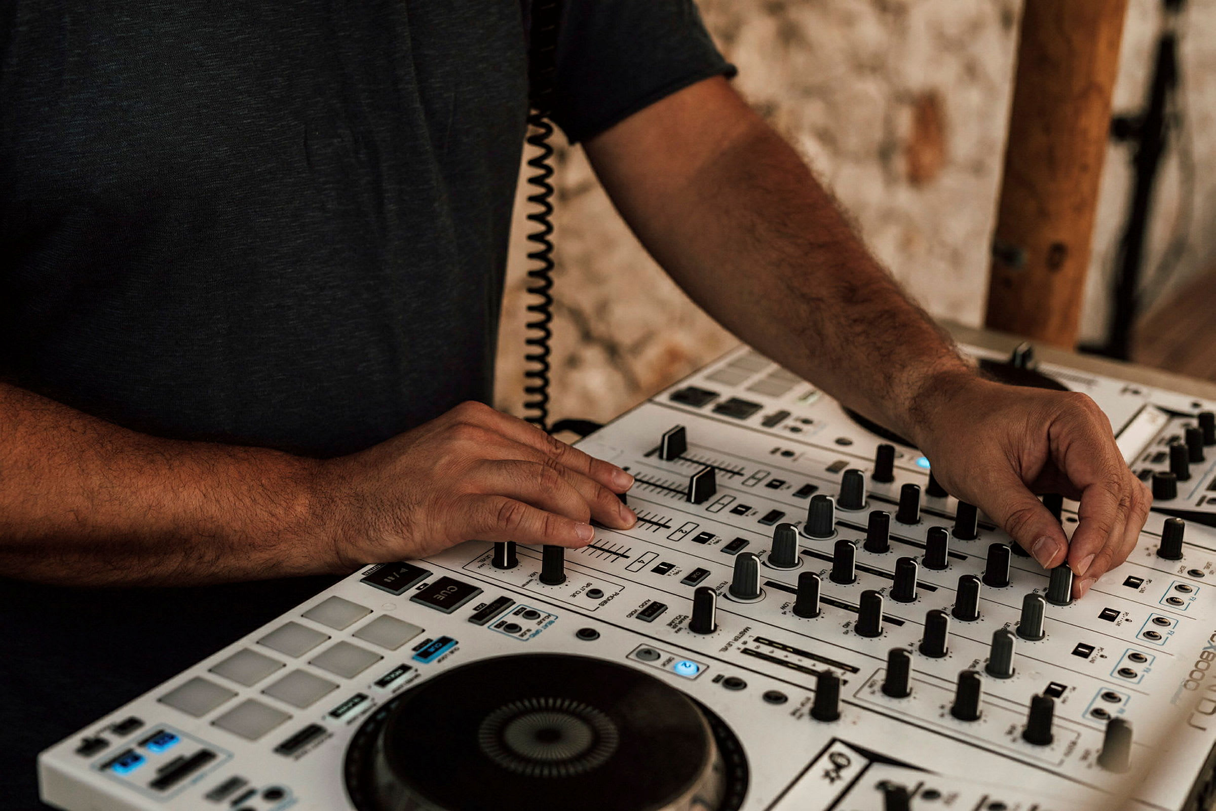 En person justerer kontroller på en DJ-mikser. (AI-generert tekst)